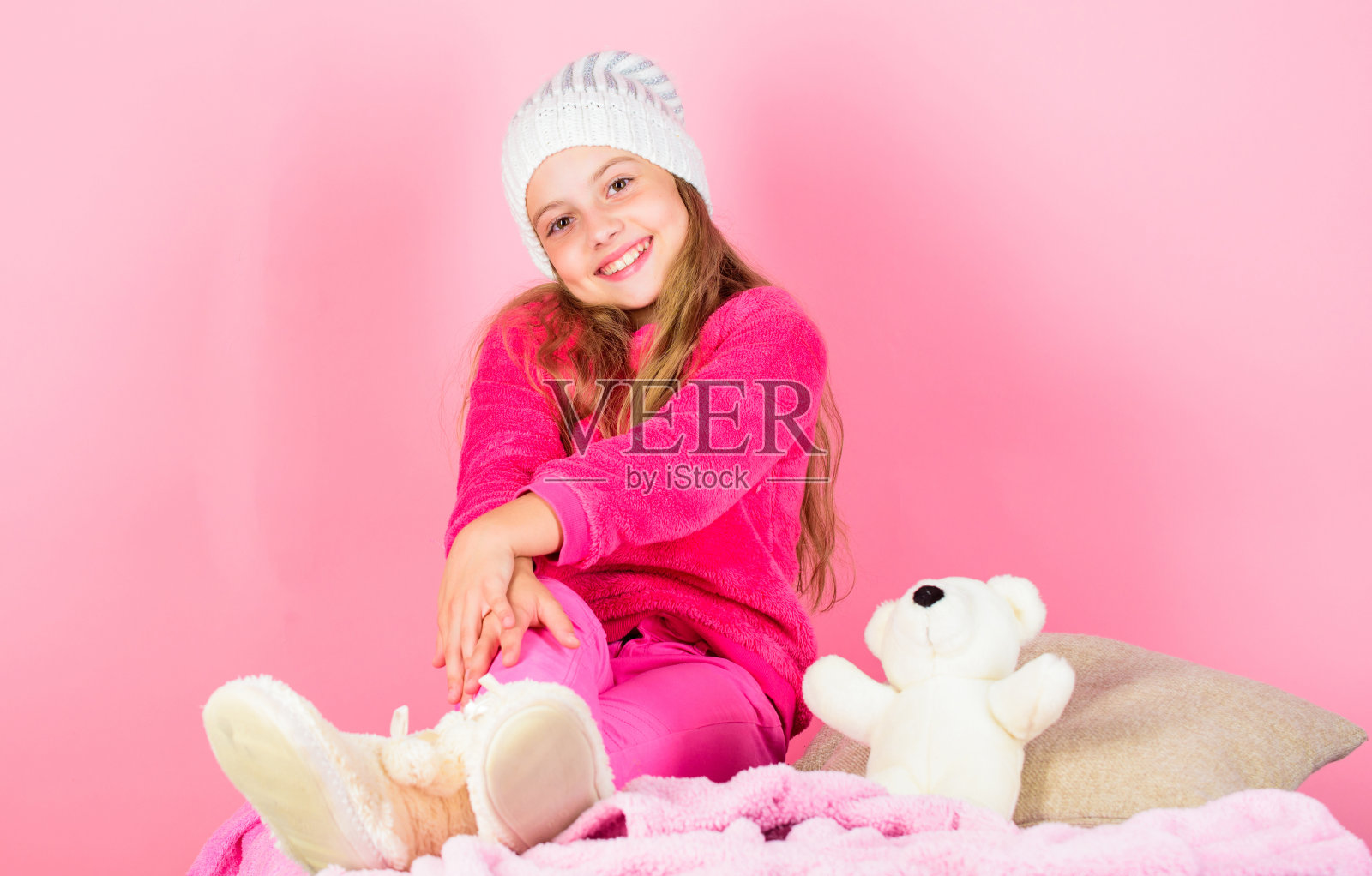 冬季的舒适属性。冬季的概念。冬天的时尚配件。小女孩织的帽子。冬季配件的概念。女孩长发梦粉色背景。孩子做梦戴针织帽照片摄影图片