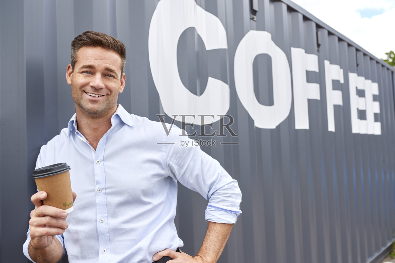 咖啡店或分销公司的男老板站在集装箱旁的肖像照片摄影图片