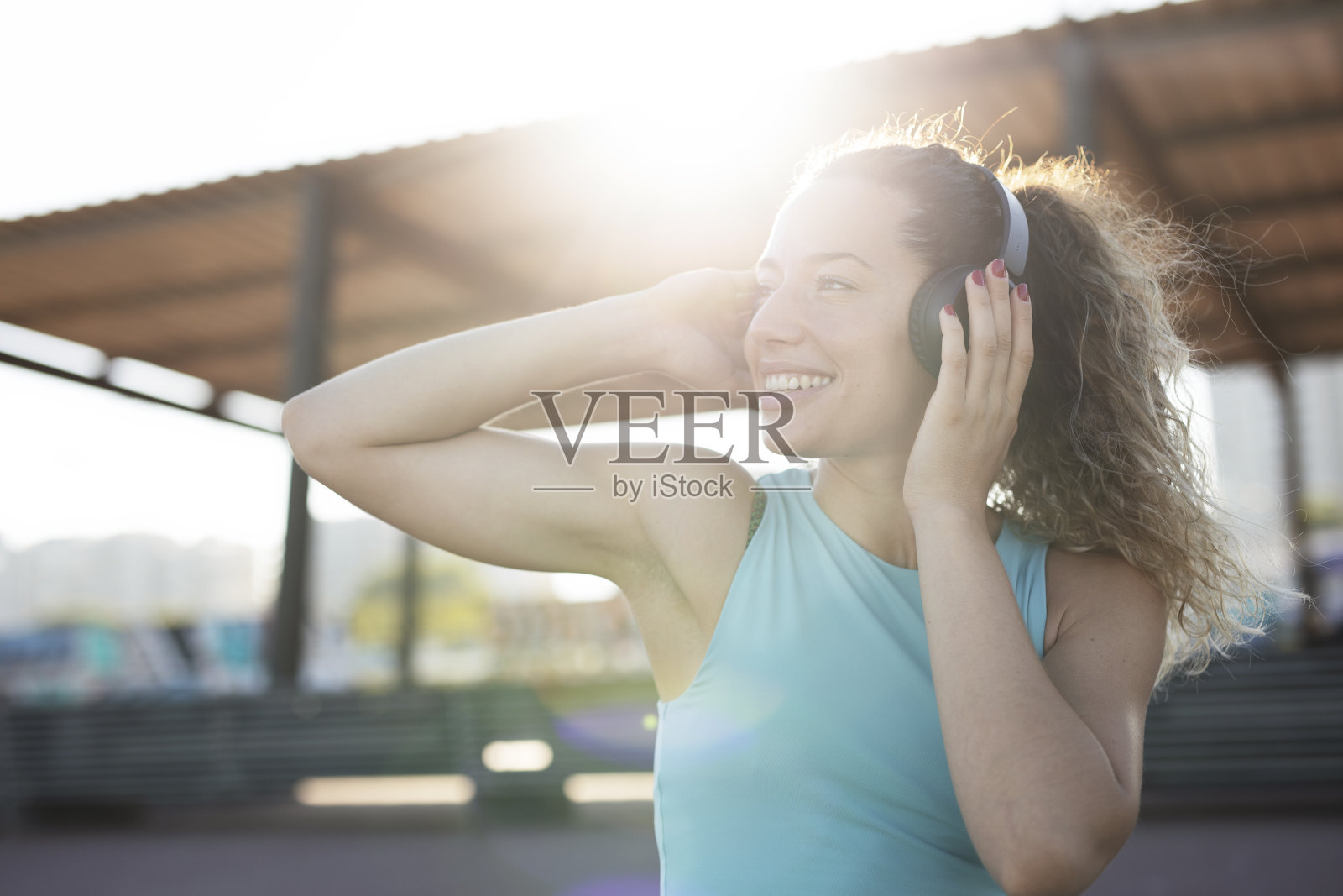 快乐的女人戴着耳机听着音乐。照片摄影图片