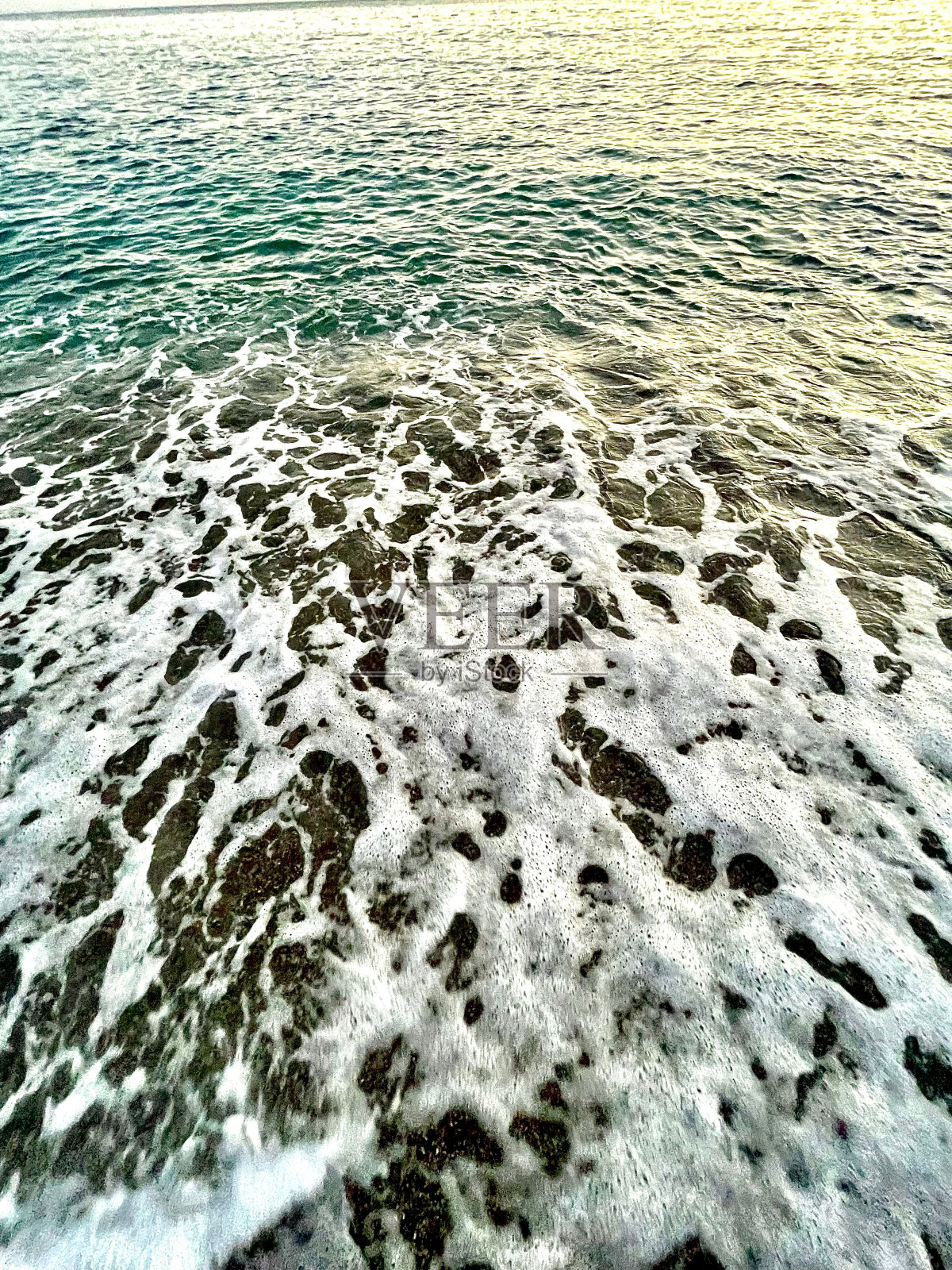 海岸上的泡沫海浪的垂直镜头照片摄影图片