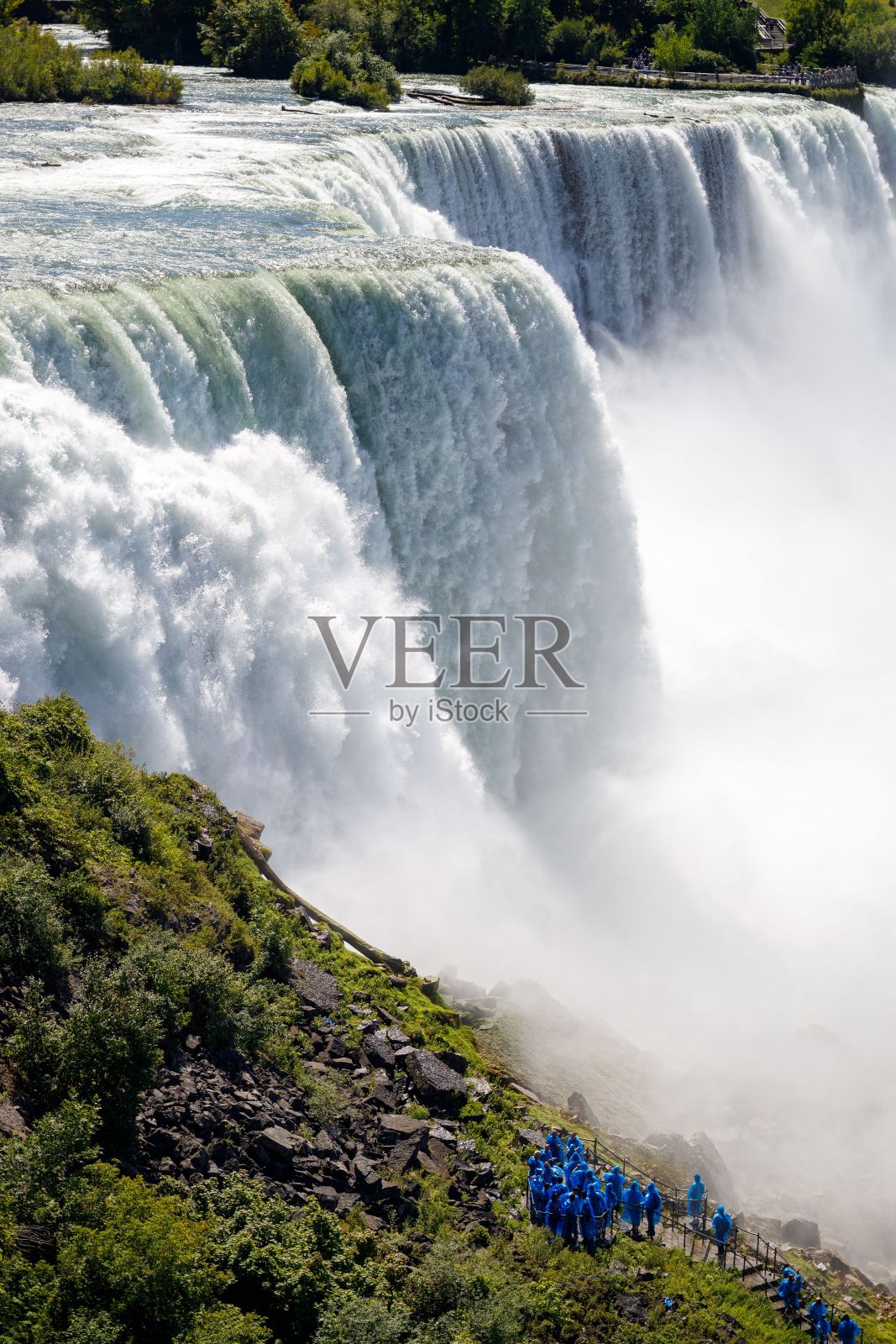 被树木环绕的汹涌瀑布照片摄影图片