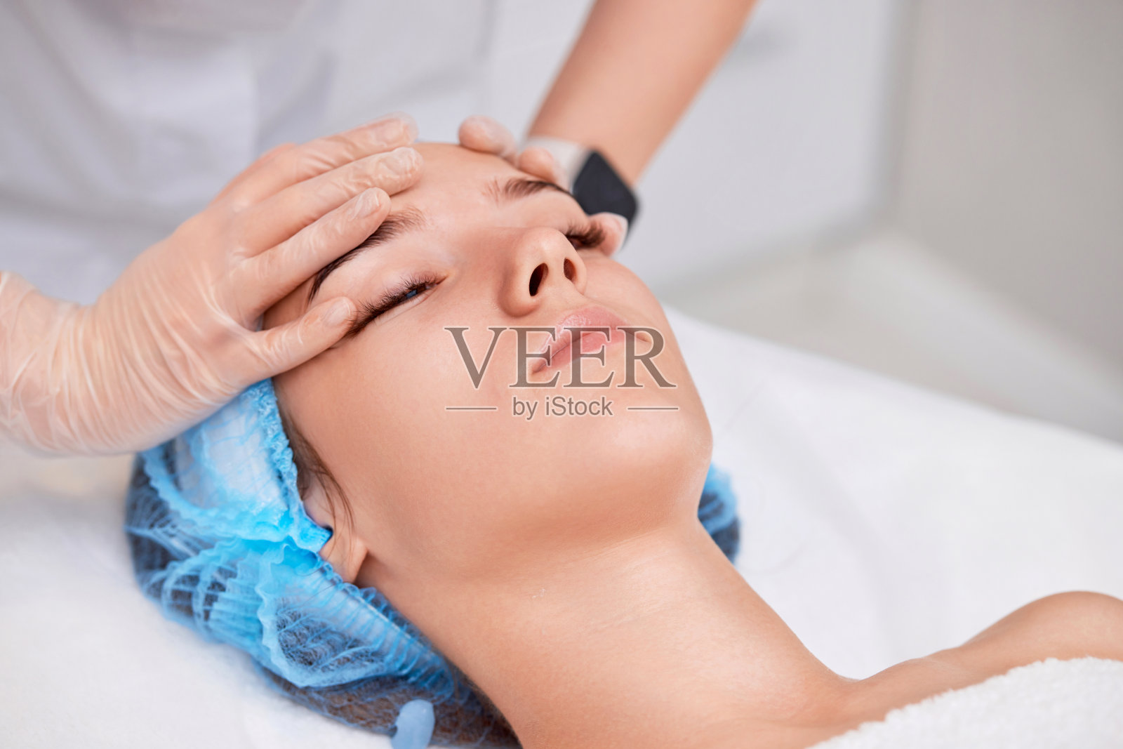 女子在水疗沙龙接受面部按摩照片摄影图片