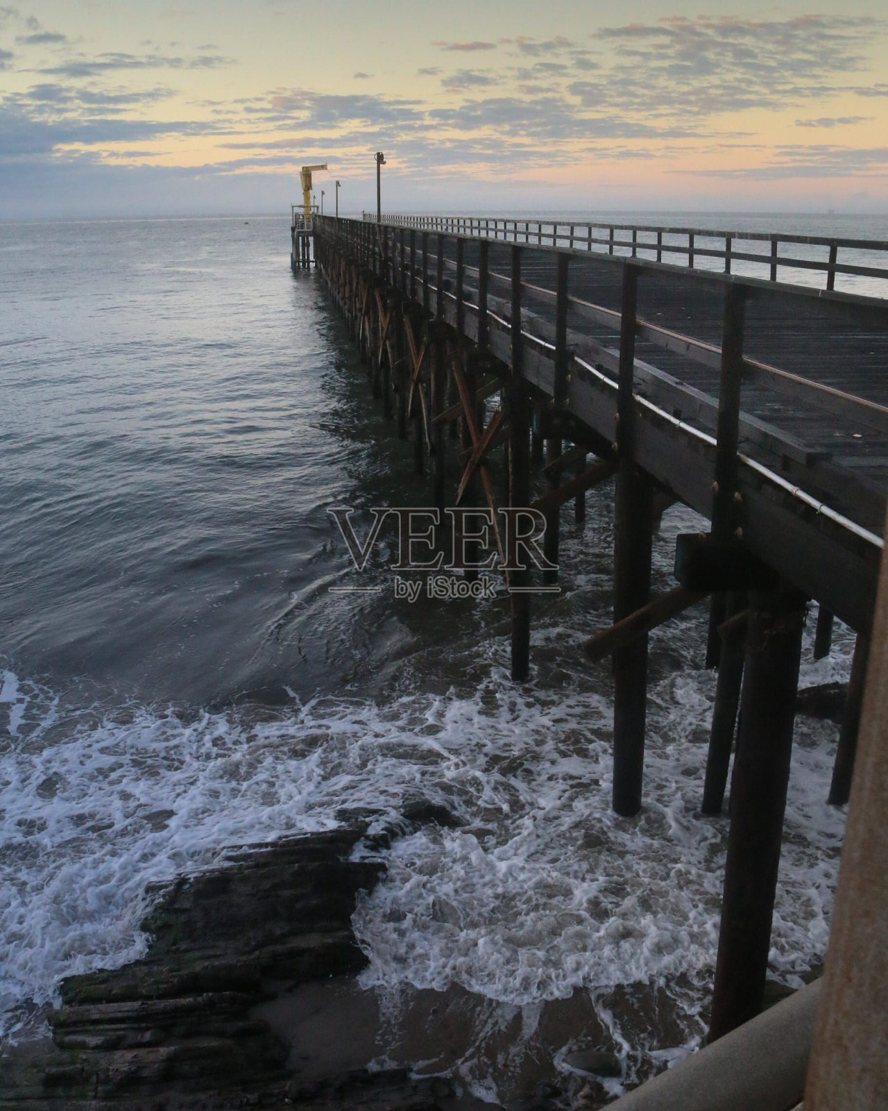 日落时天空背景下的空码头和大海的垂直拍摄。照片摄影图片