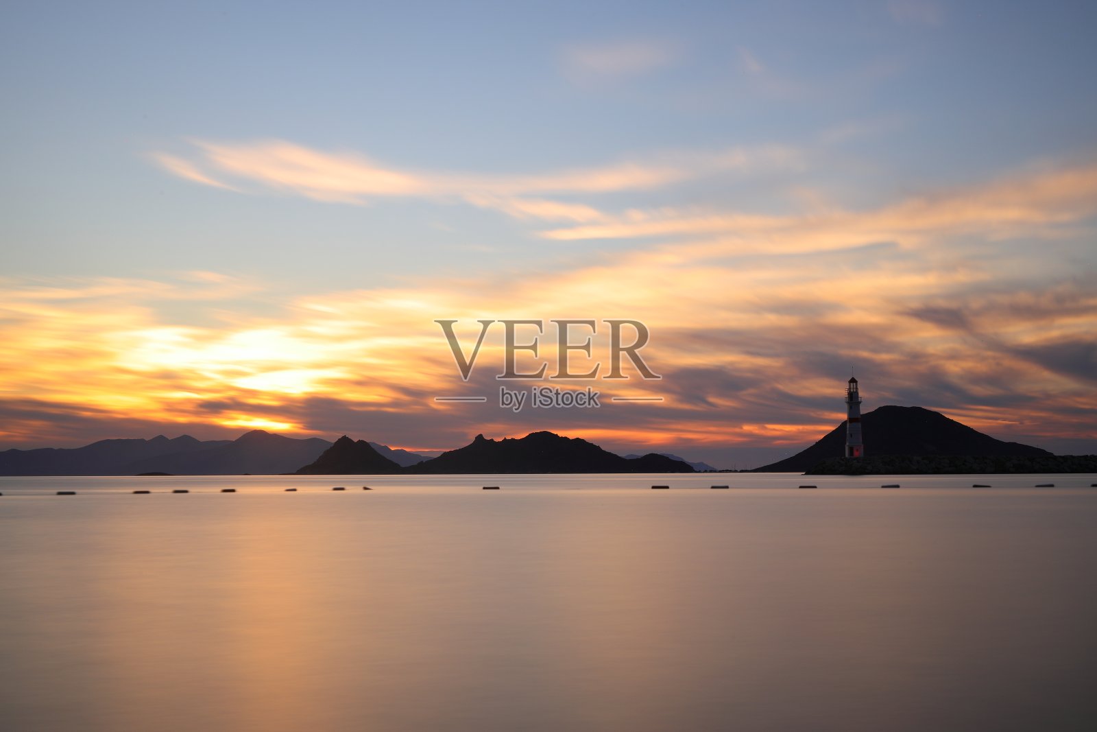 在阳光海景。灯塔和海岸上的航行。海边小镇Turgutreis和壮观的阳光照片摄影图片