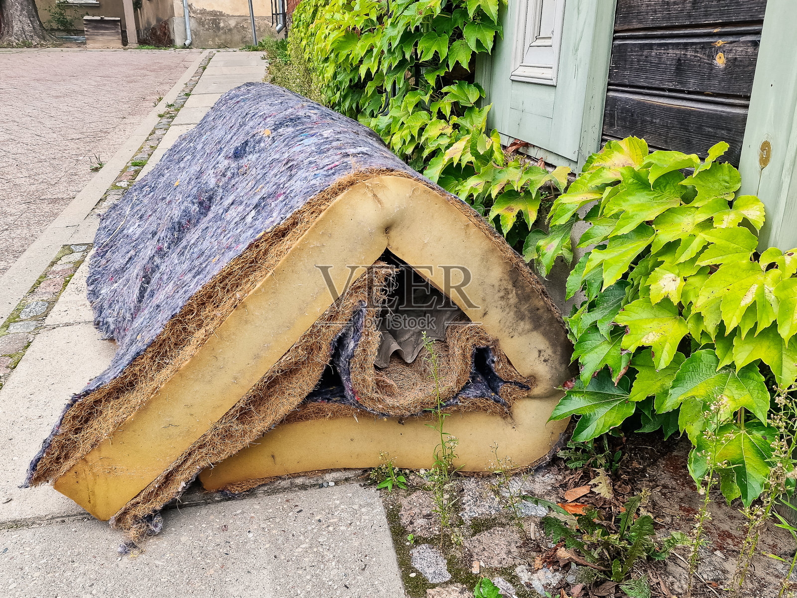 旧的，用过的床垫扔在街上。照片摄影图片