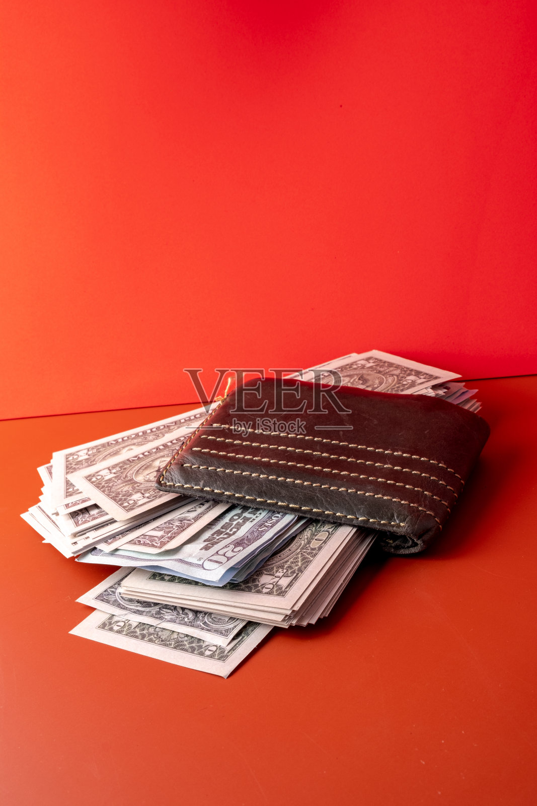 装满钱的绿色钱包。照片摄影图片