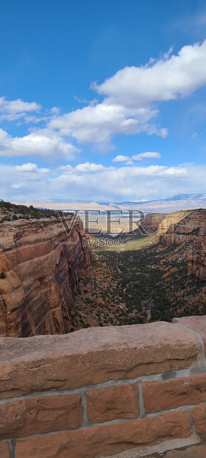 在蓝天白云下的一个巨大而美丽的峡谷上的垂直镜头照片摄影图片