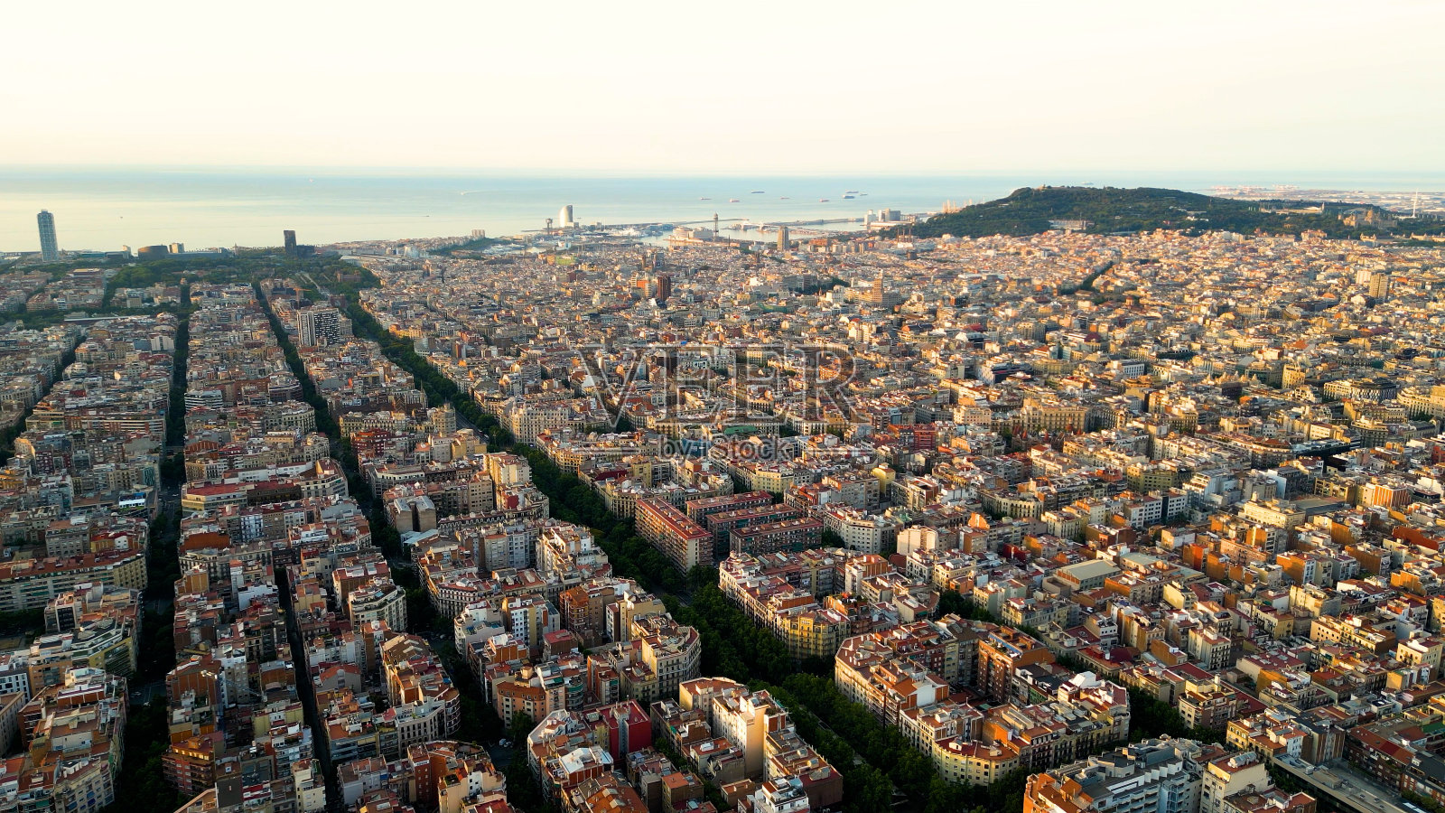 巴塞罗那城市天际线，鸟瞰图。日出时的一个住宅区。西班牙加泰罗尼亚。城市景观与典型的城市八边形街区照片摄影图片