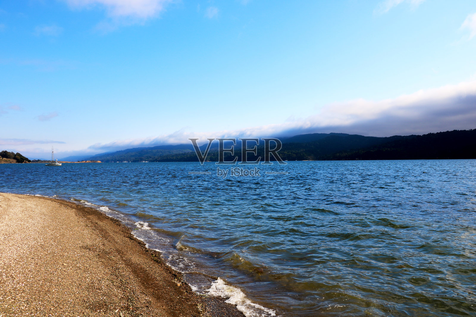 在阳光明媚的日子里，山和海洋的风景照片摄影图片