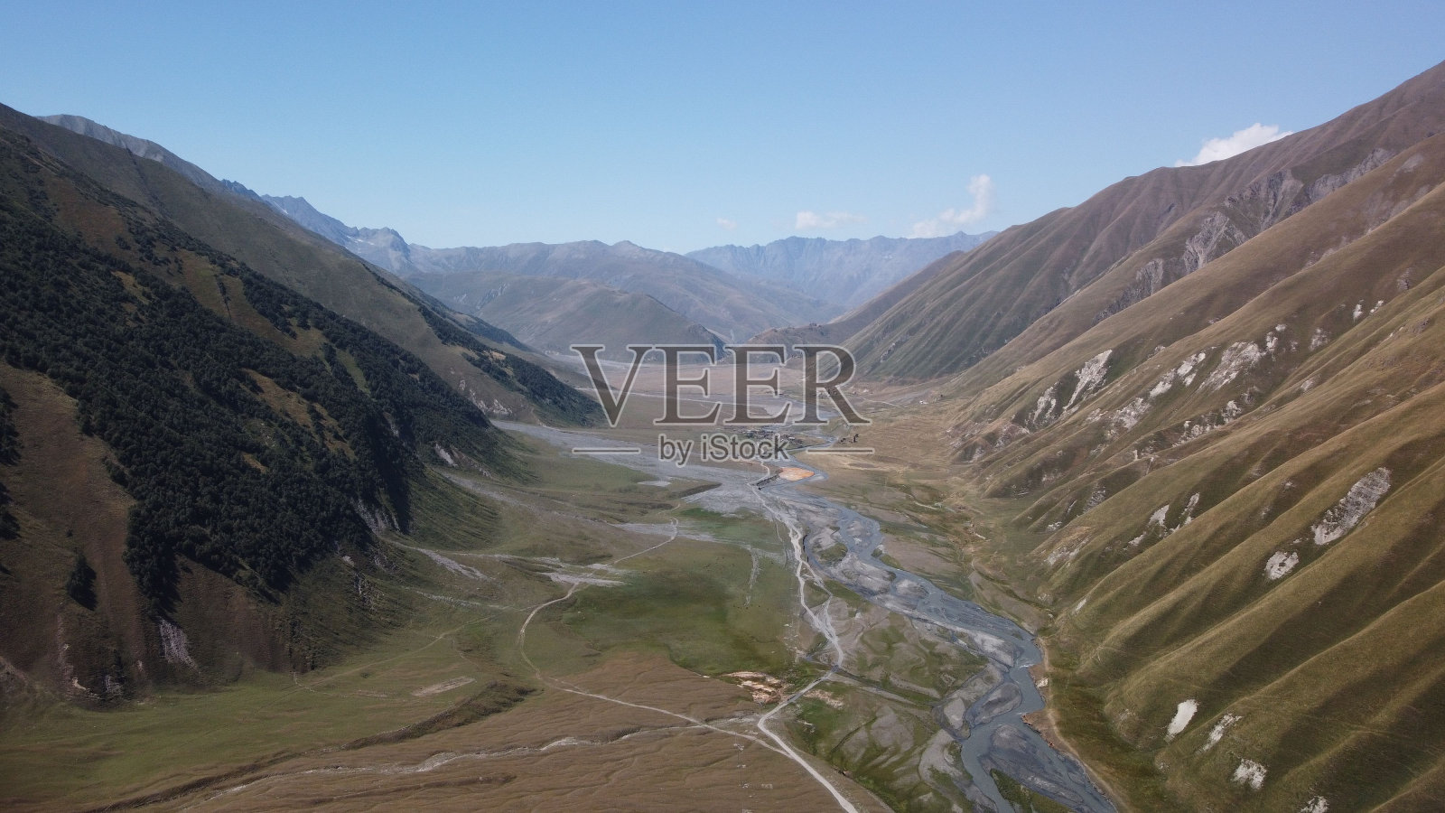 无人机拍摄的河流之间的绿色草地和草丘照片摄影图片