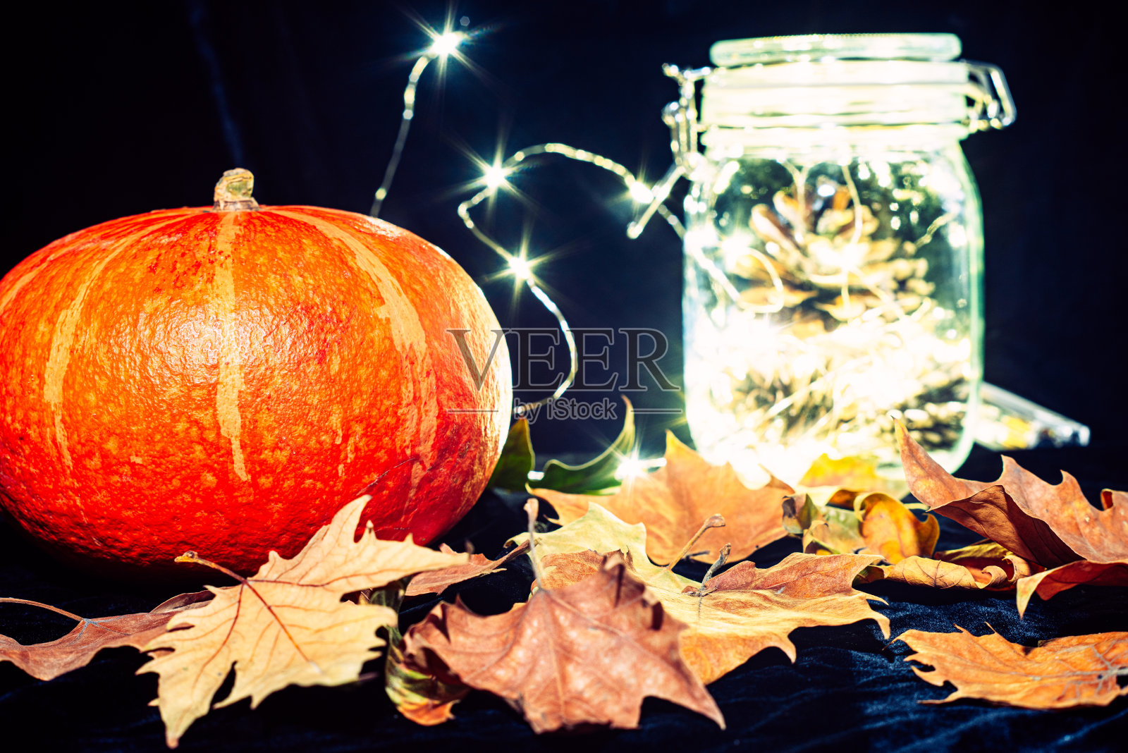 万圣节主题，南瓜和落叶在黑色天鹅绒布特写镜头照片摄影图片