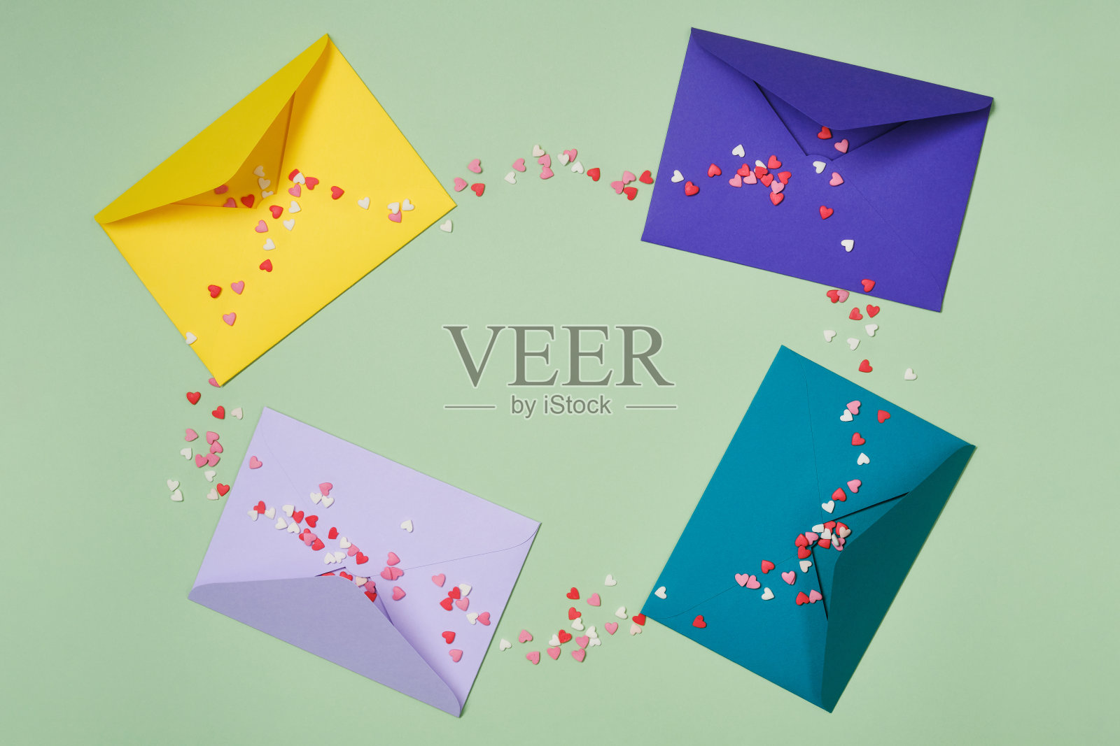 绿色背景上印有心形糖果的祝贺信封或信件。照片摄影图片