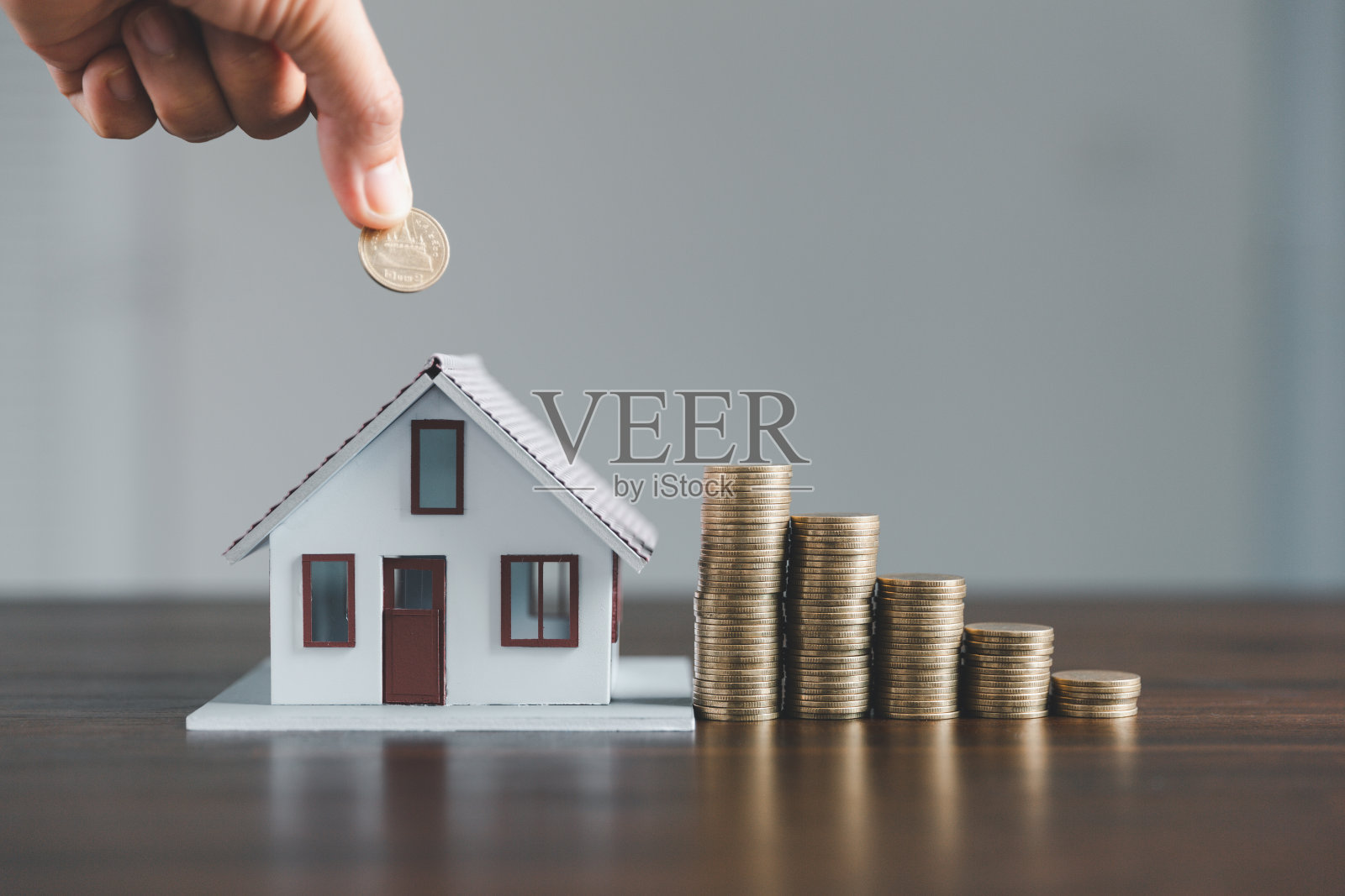 储蓄投资住房与贷款金融货币经营理念。投资银行为住宅房地产业务提供融资。把硬币和模型房子堆在一起用作投资贷款。现金税款。照片摄影图片