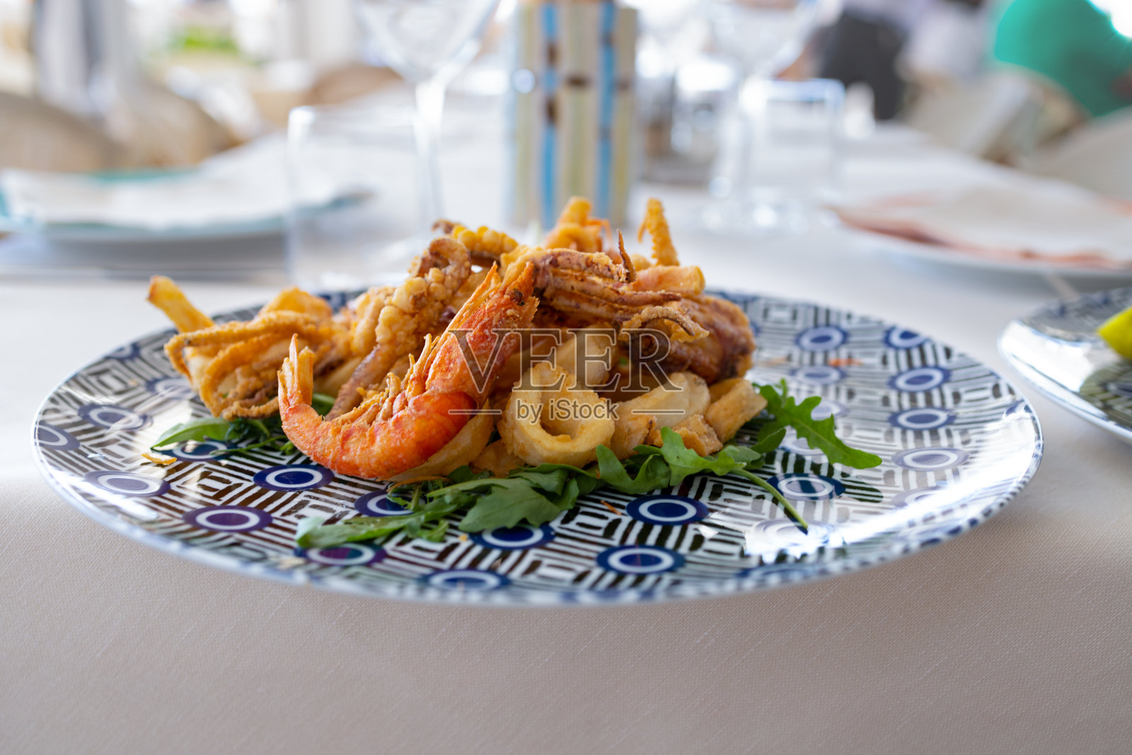 彩色的菜，炸鲜虾，鱿鱼和芝麻菜叶下面照片摄影图片