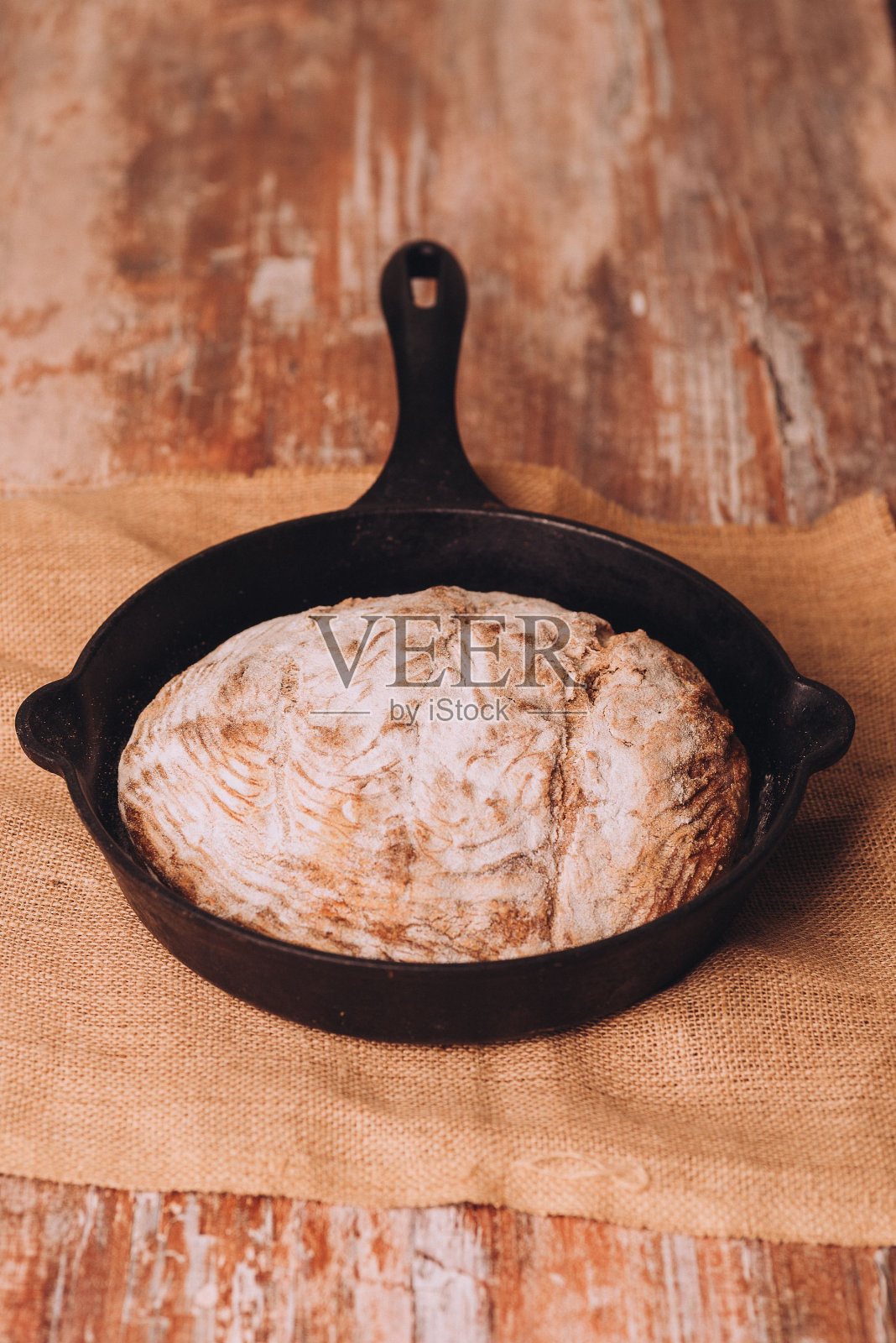 在木桌上的煎锅里新鲜烘焙的面包照片摄影图片