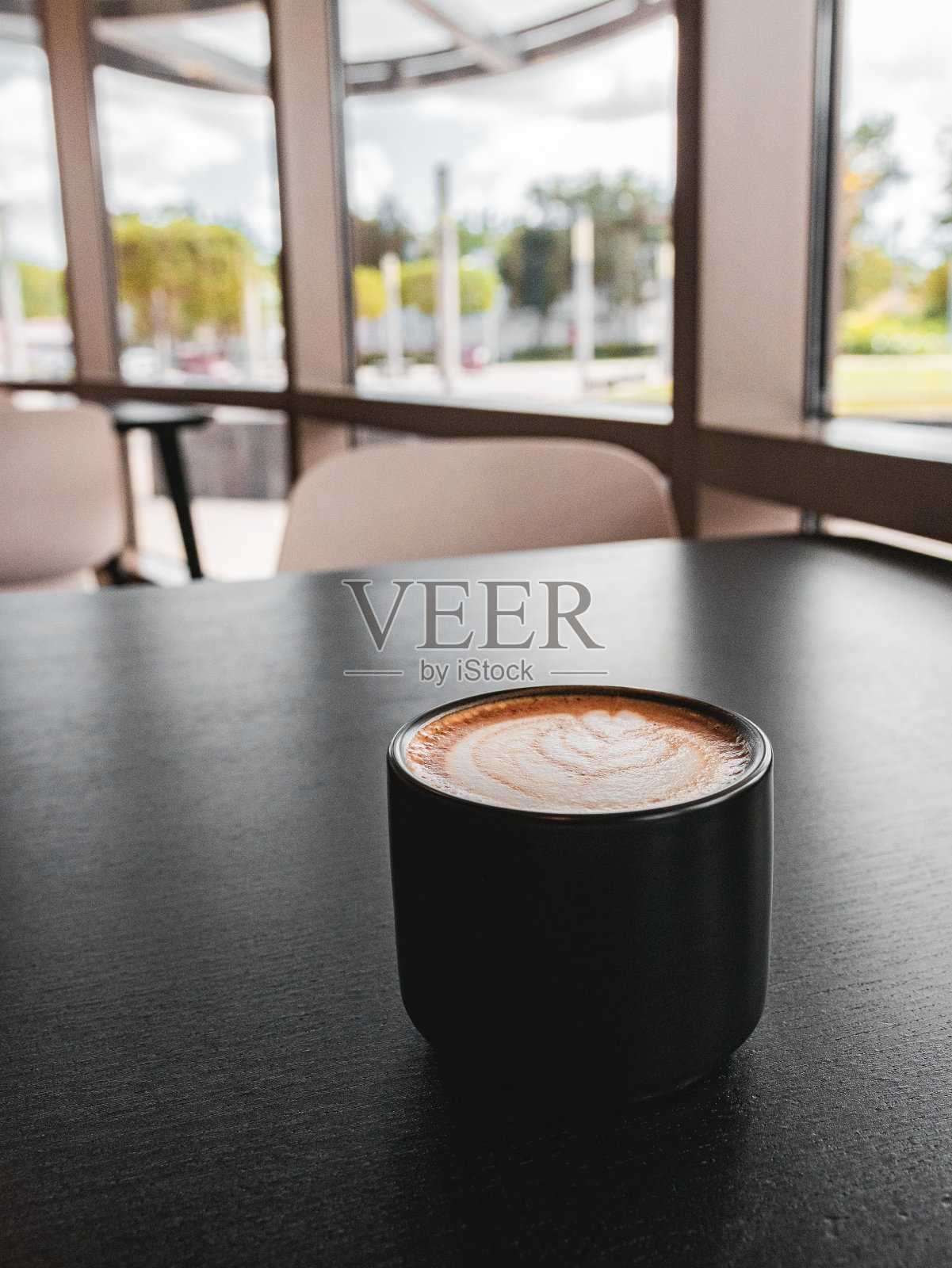 浓缩咖啡杯图片在黑色的桌子背景与心脏艺术混合牛奶。咖啡师的咖啡艺术，上面有拿铁牛奶。美味的咖啡壁纸。coffeshop和平环境。照片摄影图片