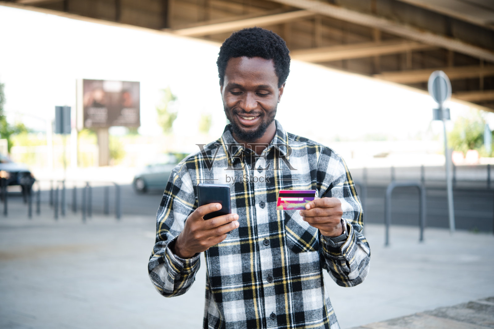 一个快乐的非洲人使用智能手机进行网上购物的画像照片摄影图片