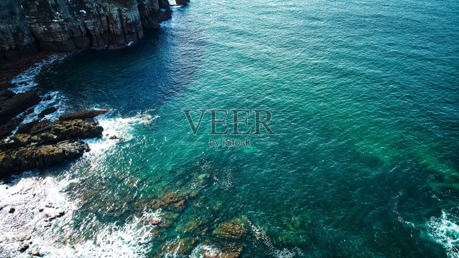 海面上的泡沫海浪接近岩石海岸的鸟瞰图照片摄影图片