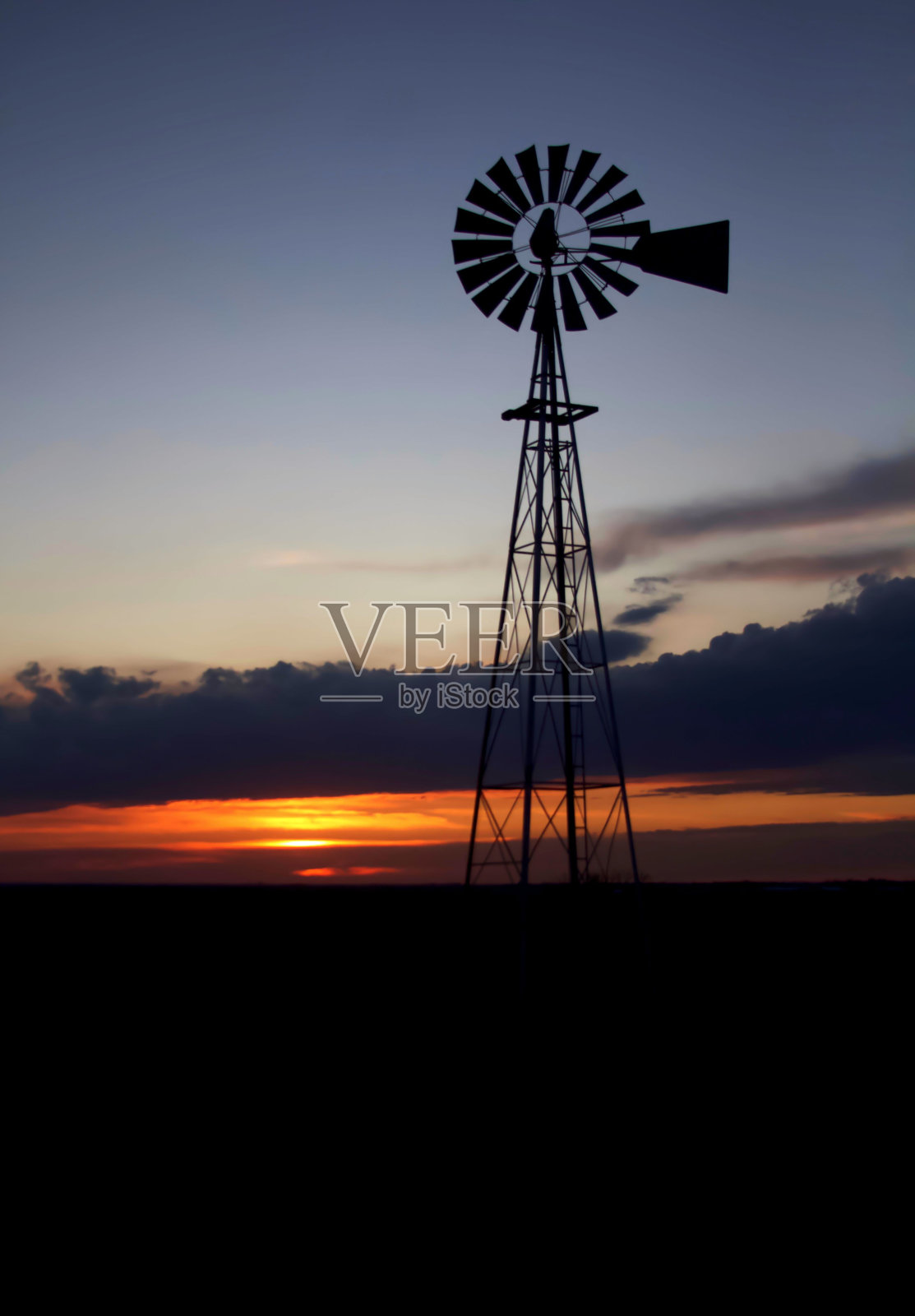 日落时一根杆子剪影的垂直镜头照片摄影图片