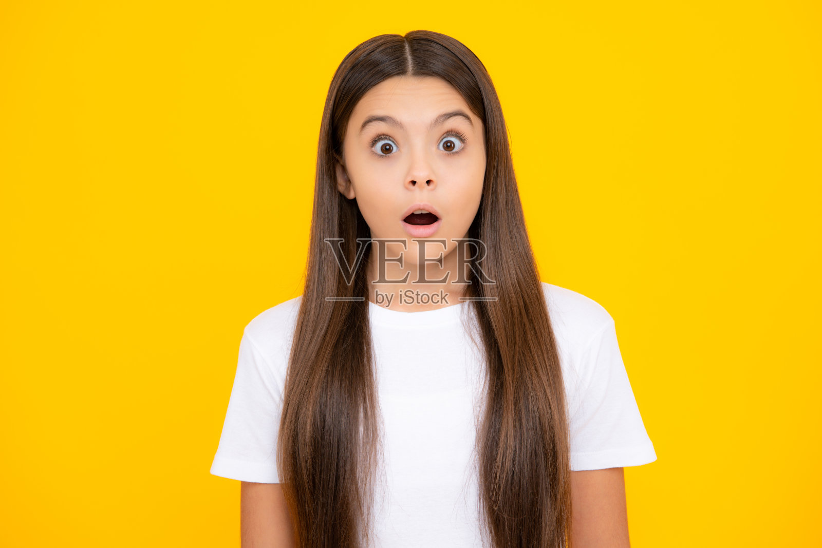 震惊的青少年儿童肖像孤立在黄色背景。少女感到惊讶。年轻少女惊讶的情绪。照片摄影图片