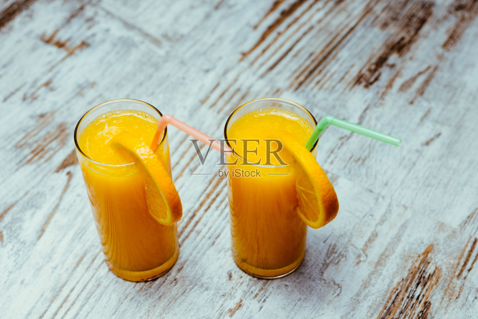 木桌上的两个橙汁杯的特写镜头照片摄影图片