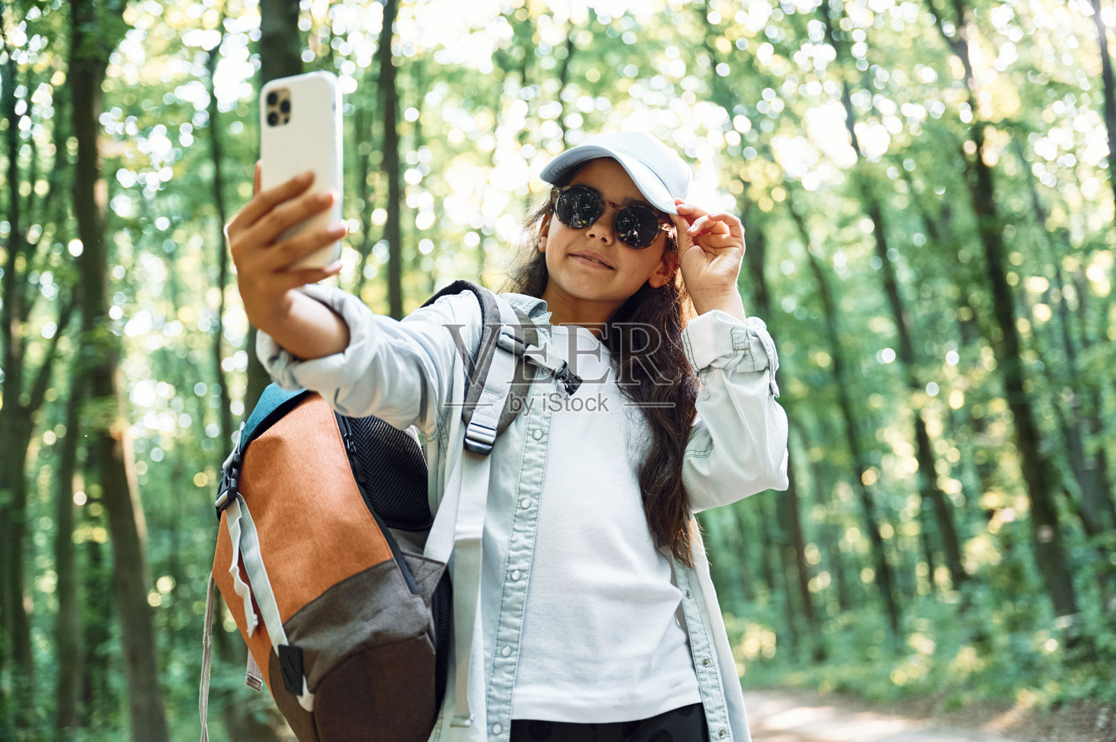 用手机自拍。夏天的一天，女孩在森林里发现新的地方照片摄影图片