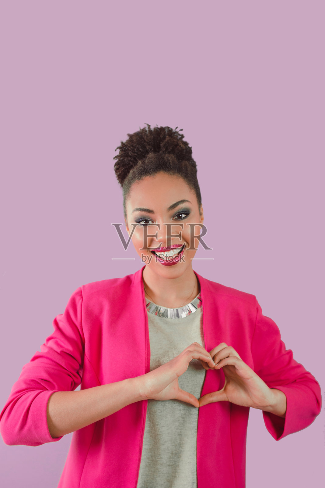 美丽的迷人的快乐的微笑的年轻女子(混合提高)握着她的手作为心和显示她的爱。爱，支持，团结，关怀，多元化的理念照片摄影图片