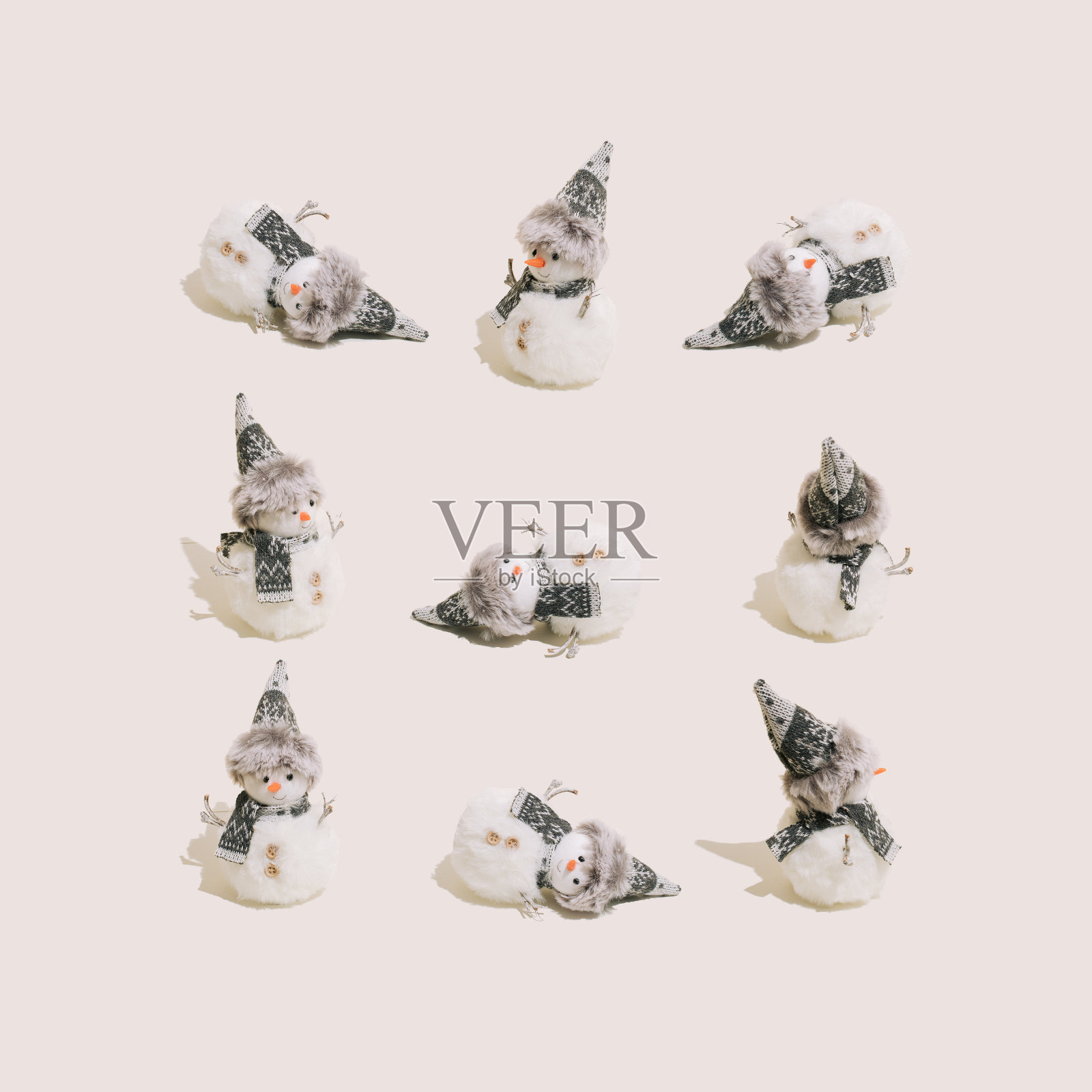 在柔和的米色背景上摆出不同滑稽姿势的雪人。寒假、圣诞节、新年的创意作文。照片摄影图片