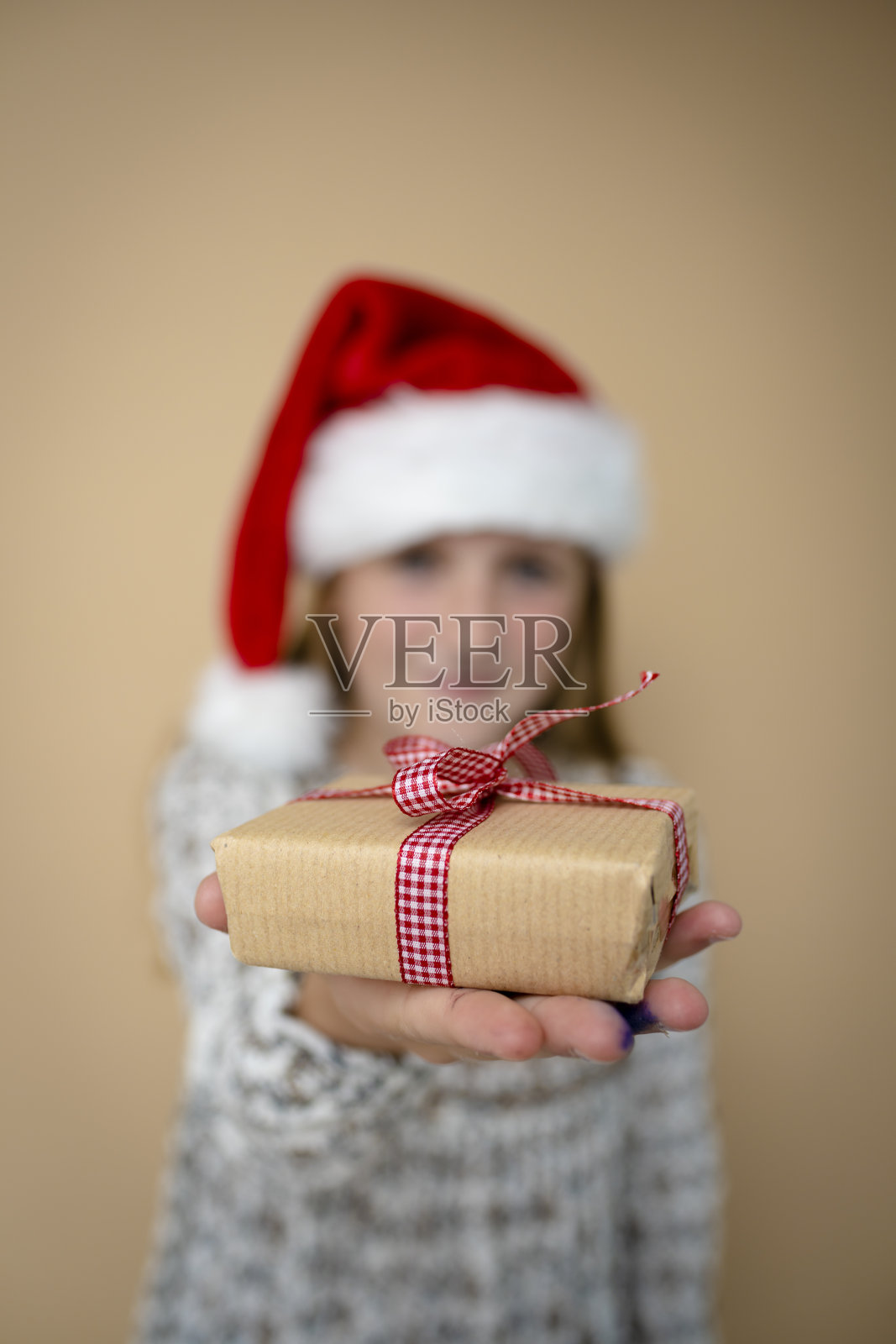 戴着圣诞老人帽子和礼物的小女孩照片摄影图片