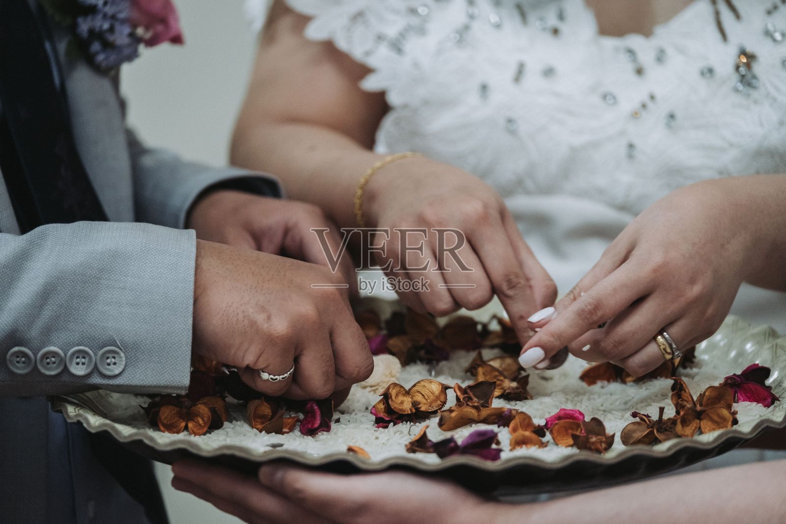 新娘和新郎从盘子里拿干果的特写镜头照片摄影图片