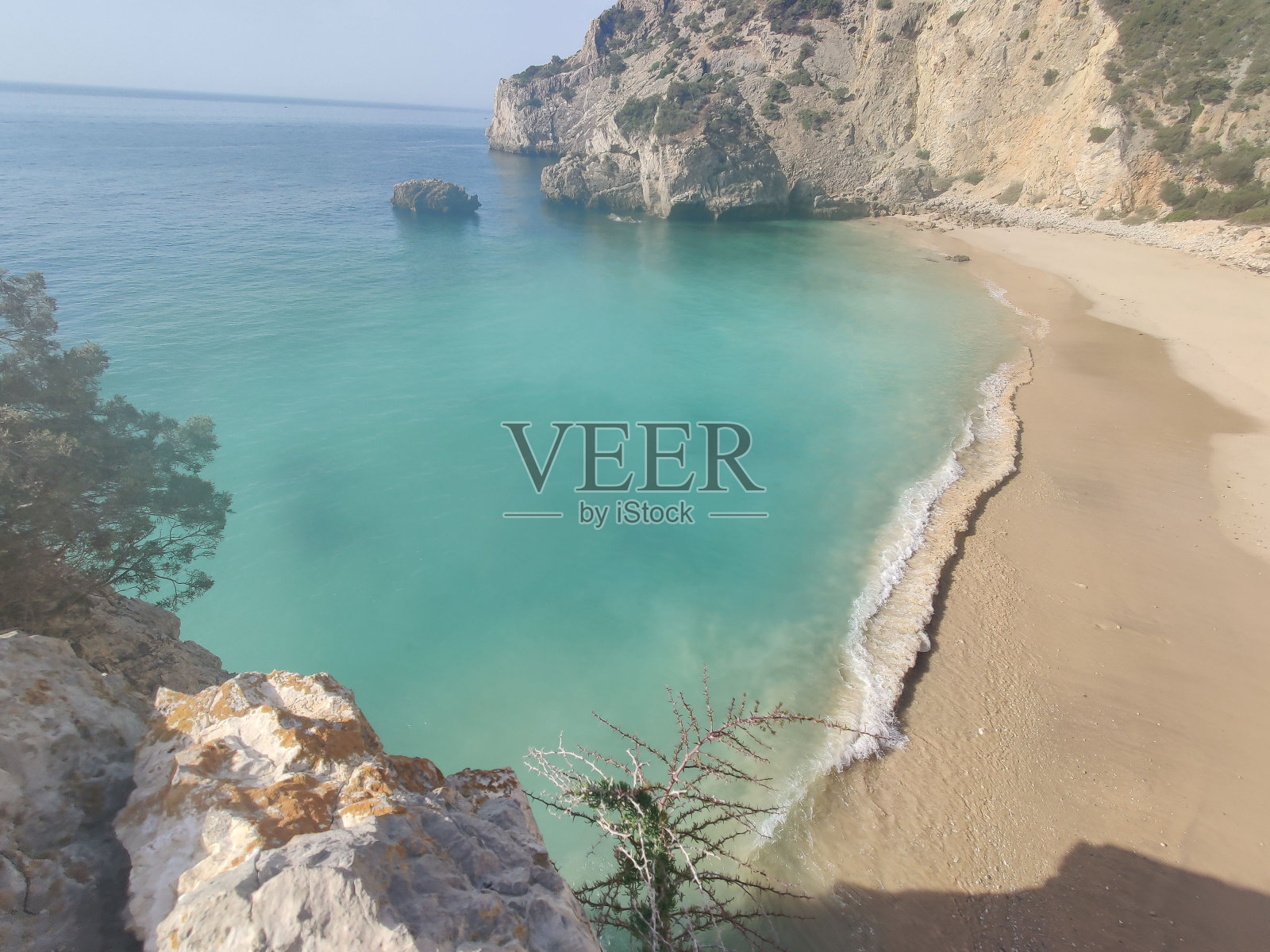 海滩的鸟瞰图，有清澈的绿色海水和岩石峭壁。照片摄影图片