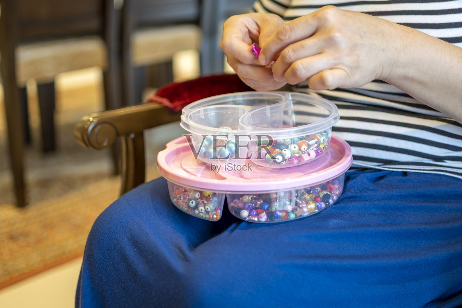 用手将塑料颗粒放入测量容器中照片摄影图片