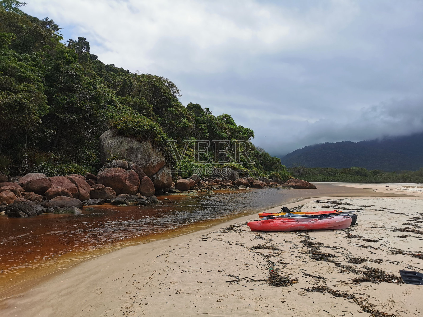河堤上的红船。风景优美的青山在多云的天空背景下照片摄影图片