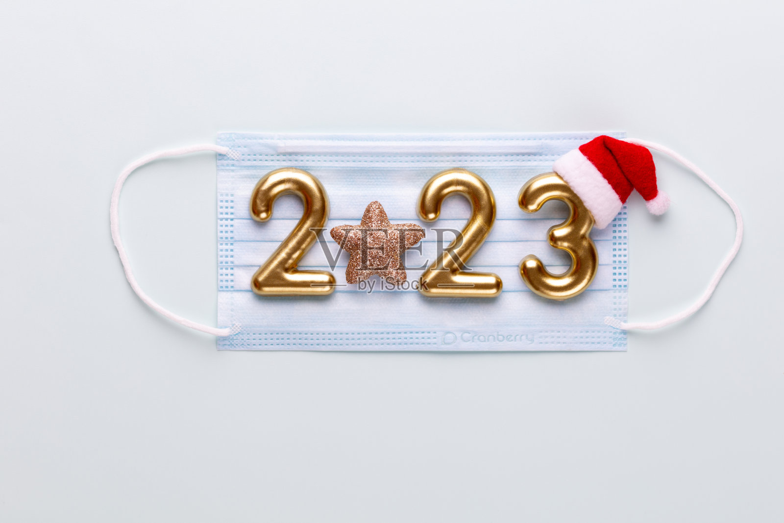 2023年新年数字，金色数字和蓝色背景的圣诞老人帽子。照片摄影图片