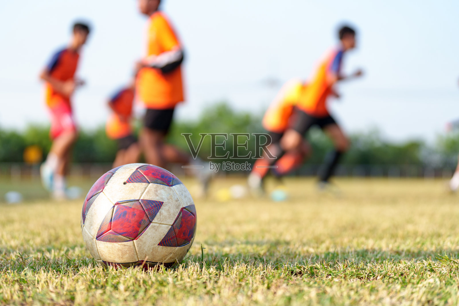 孩子们跑着踢着足球。少儿足球培训课程。照片摄影图片