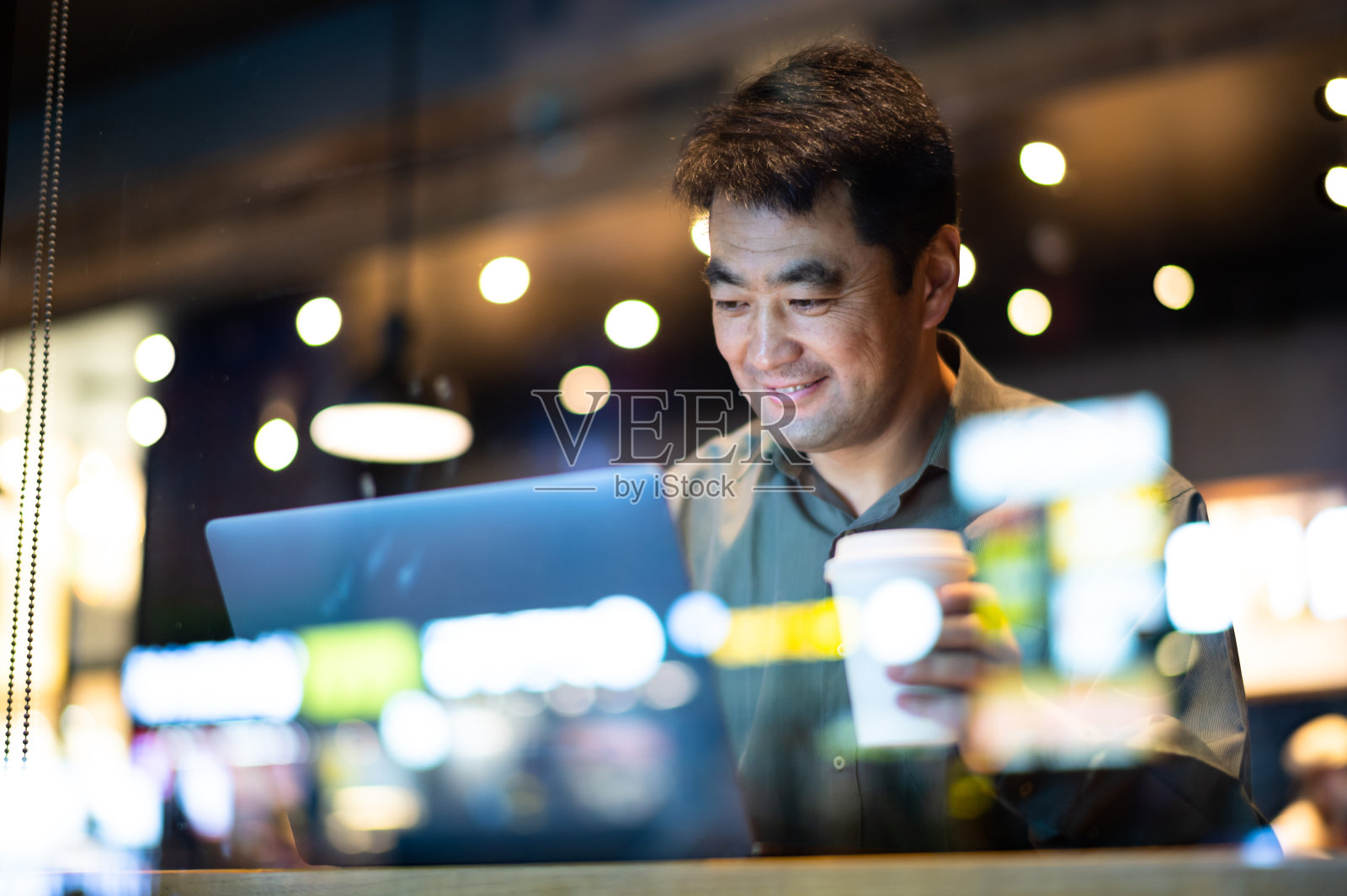 亚洲中年男子在咖啡店使用笔记本电脑照片摄影图片