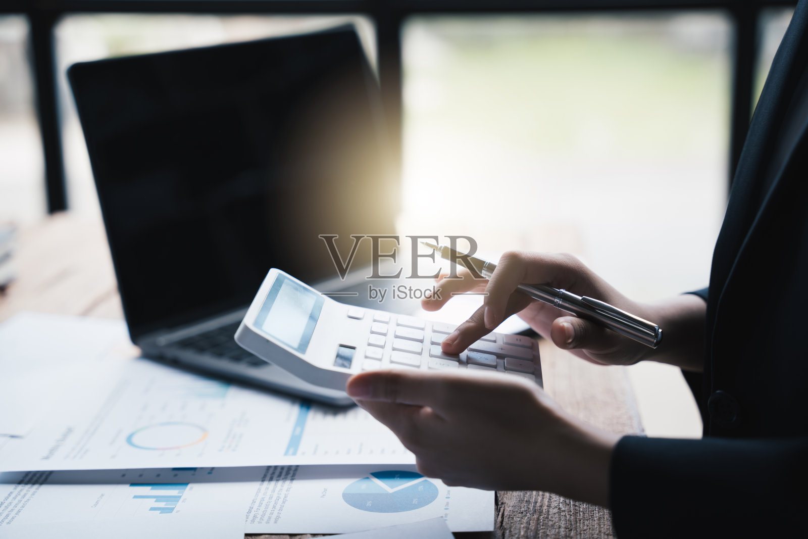 商业妇女使用计算器计算数字和计算机分析统计业务文件在办公室，财务会计的概念照片摄影图片