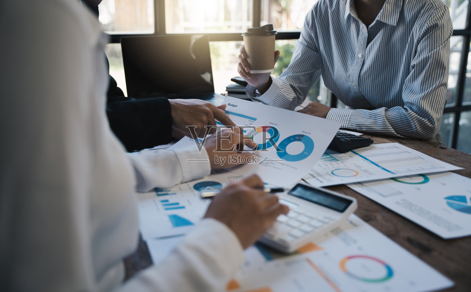 一组员工分析财务业绩，关注每月预算，金融工具图表，业务办公室概念。照片摄影图片