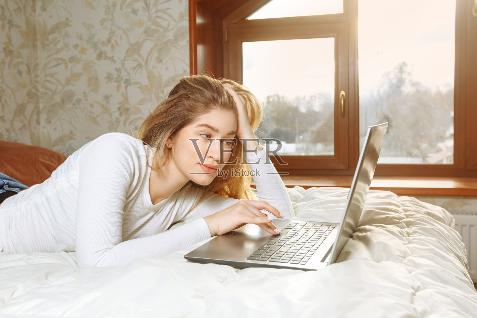 一个女孩在家里远程学习或工作。照片摄影图片