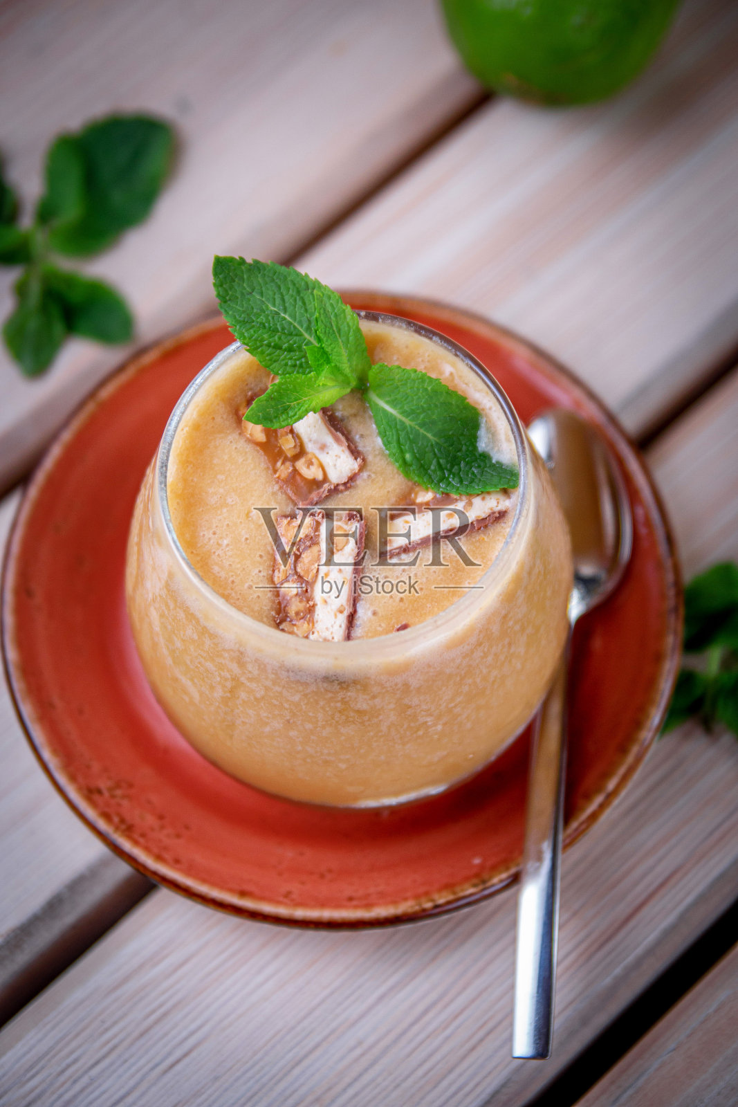 酒精清新的杜松子酒奎宁鸡尾酒，桃子冰沙和薄荷冰块，在餐厅的夏季露台上。桃子的饮料照片摄影图片