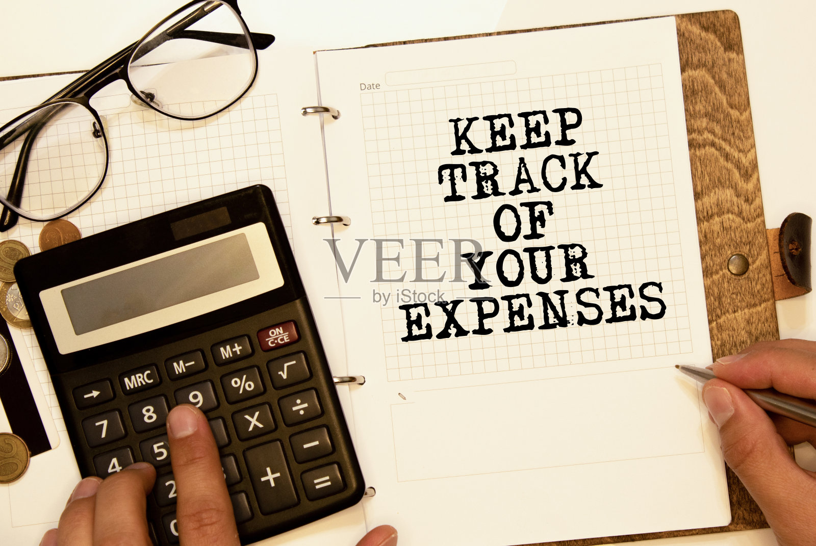 在木制桌子背景上记录你的开支。经营理念。照片摄影图片