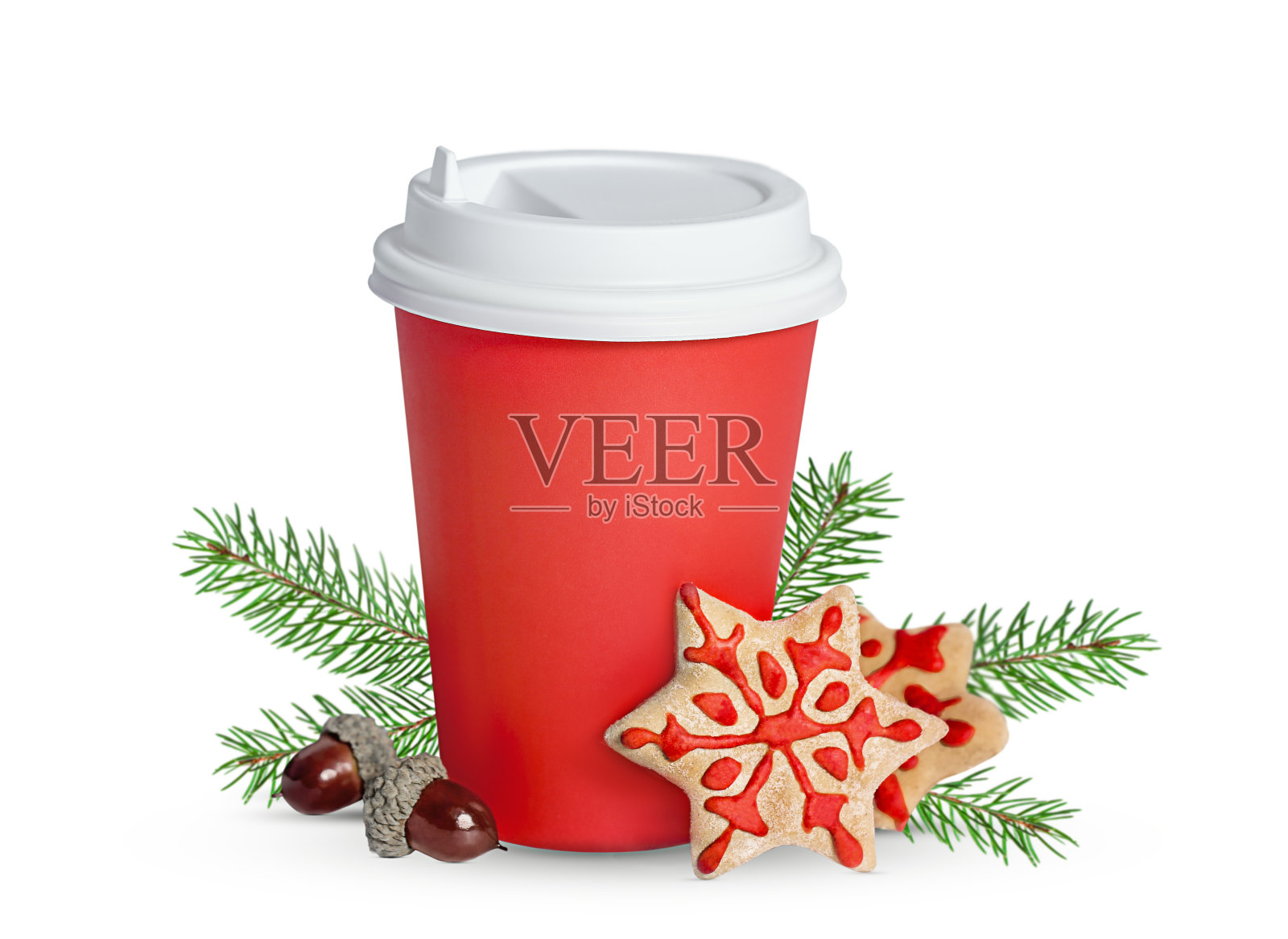 白色的背景上是一个红纸杯，里面有姜饼、橡子和云杉树枝照片摄影图片