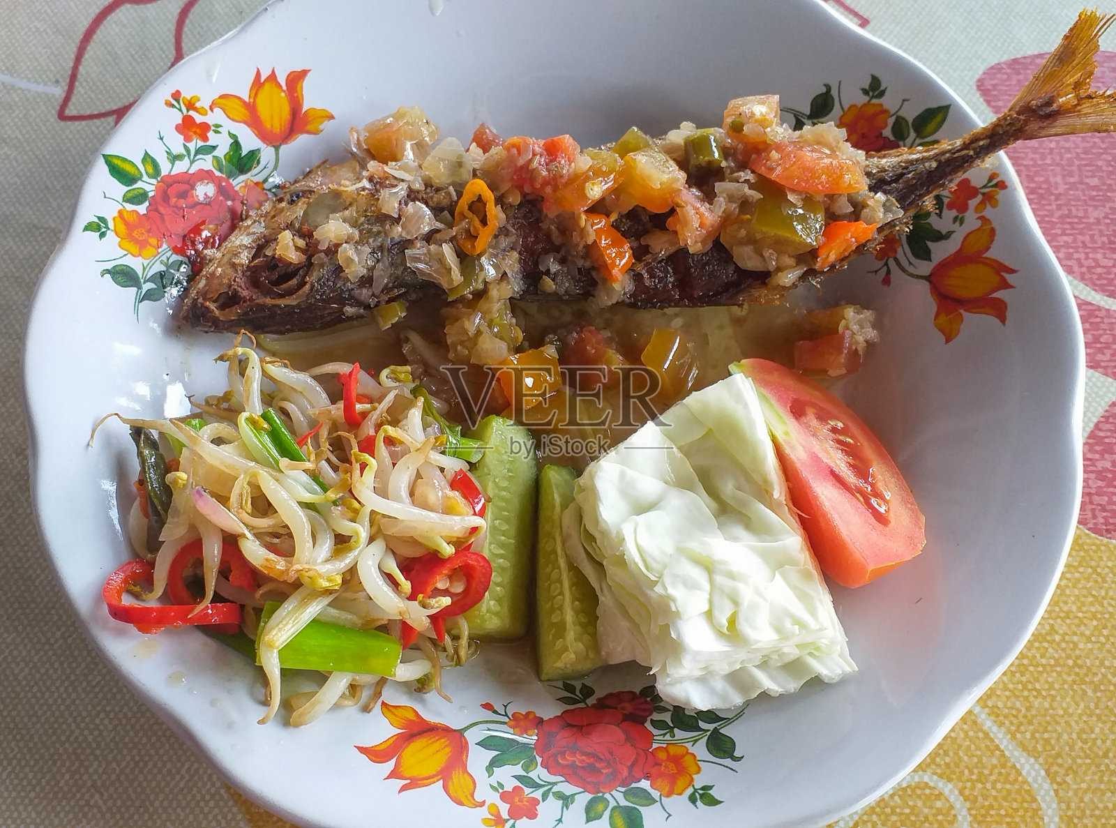 印尼美食——炸鲭鱼或红凉拌拌鱼，辣椒炸豆芽和卷心菜、西红柿和黄瓜沙拉。照片摄影图片