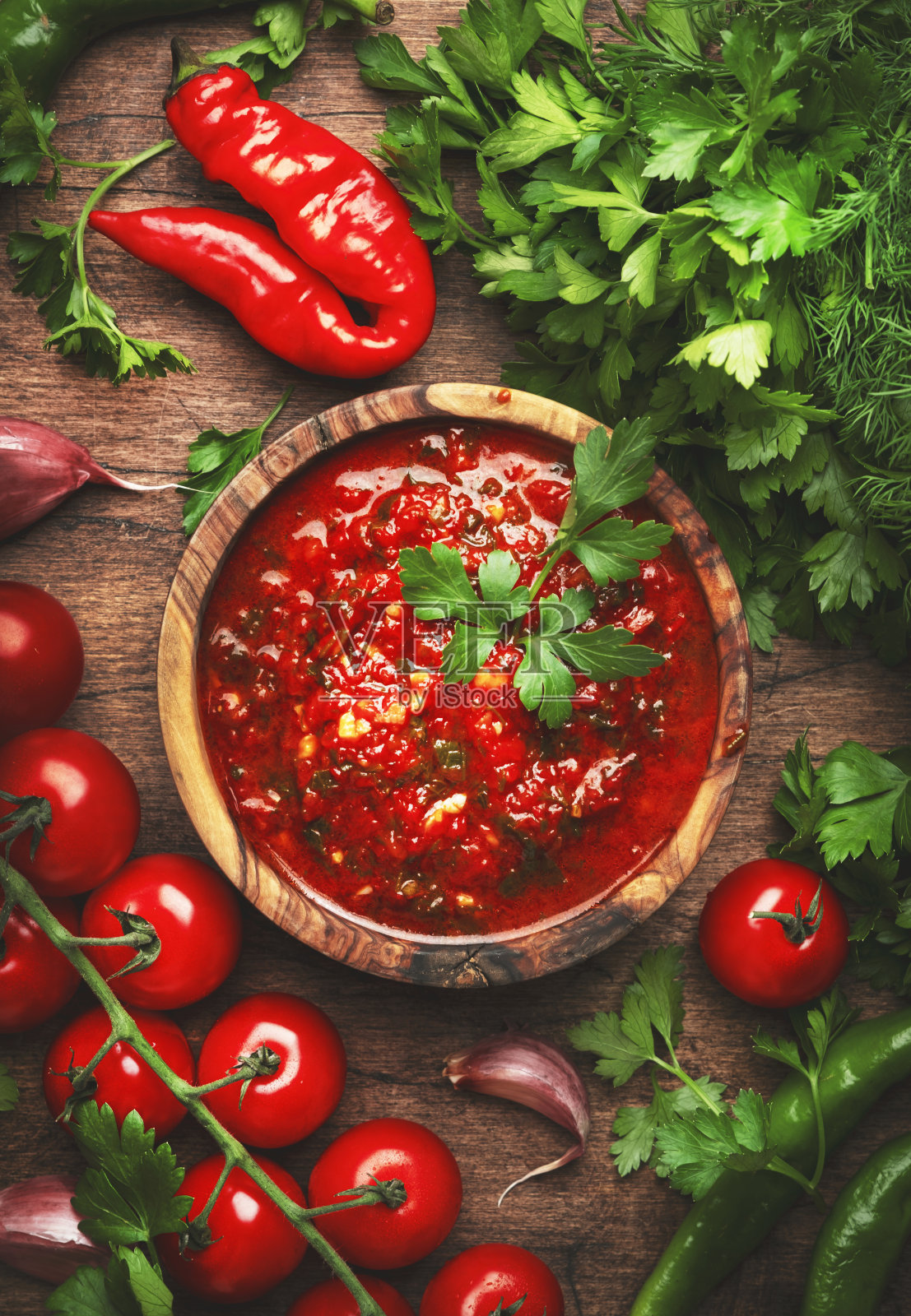 白种人的菜。传统亚美尼亚热adjika酱与辣椒，辣椒粉，大蒜和欧芹在乡村木厨房餐桌背景，俯视图照片摄影图片