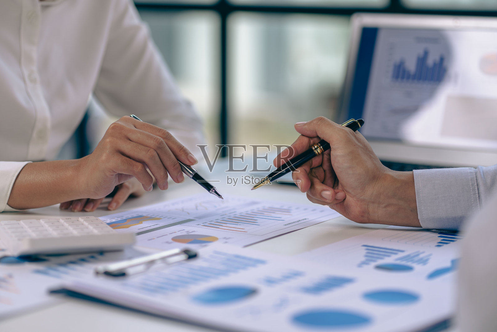 在办公室里从事财务分析和市场销售策略的业务人员团队。团队工作，笔记本电脑财务图表文件在桌上照片摄影图片