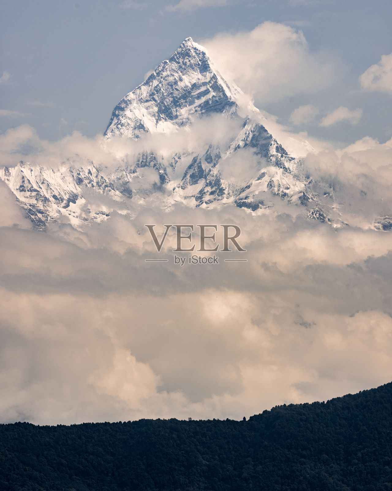 Machapuchare又名鱼尾山，被云覆盖的雪峰，喜马拉雅山脉，尼泊尔。照片摄影图片