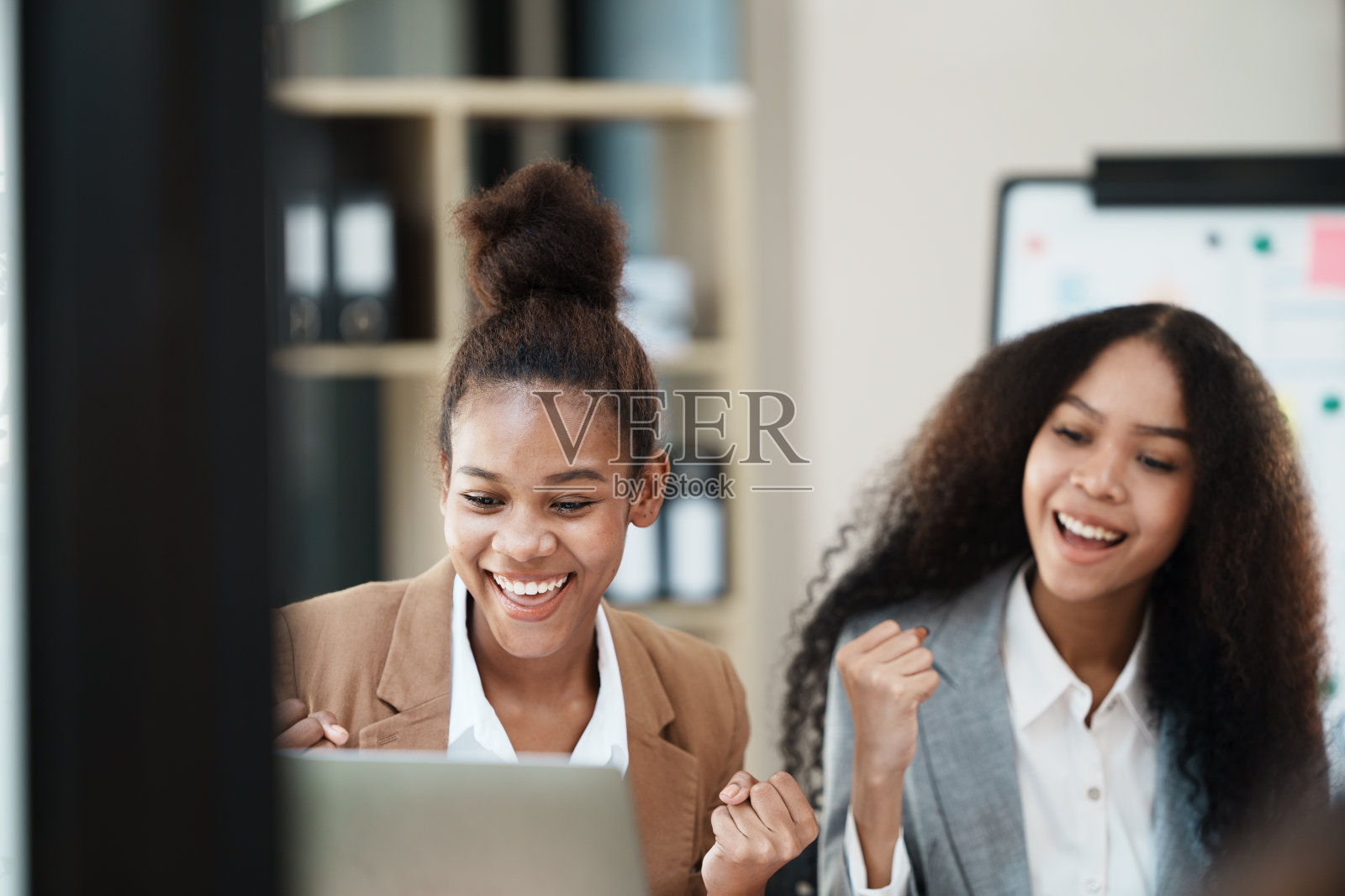 两个女人开会，在团队里收到了好消息。照片摄影图片