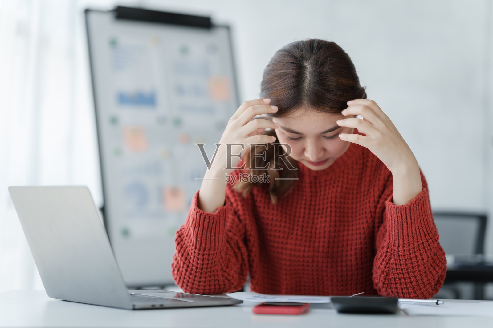 在办公室用笔记本电脑工作，很难过，很担心，很努力，工作过度的概念。照片摄影图片