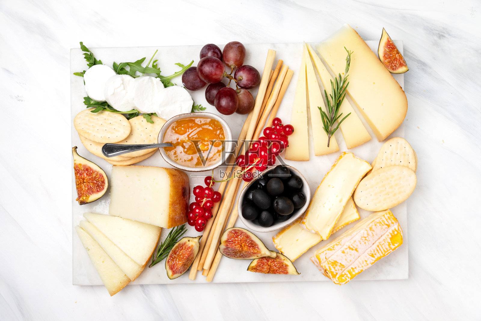 芝士盘配佩科里诺干酪布里干酪山羊奶酪饼干面包棒无花果果酱橄榄和浆果照片摄影图片
