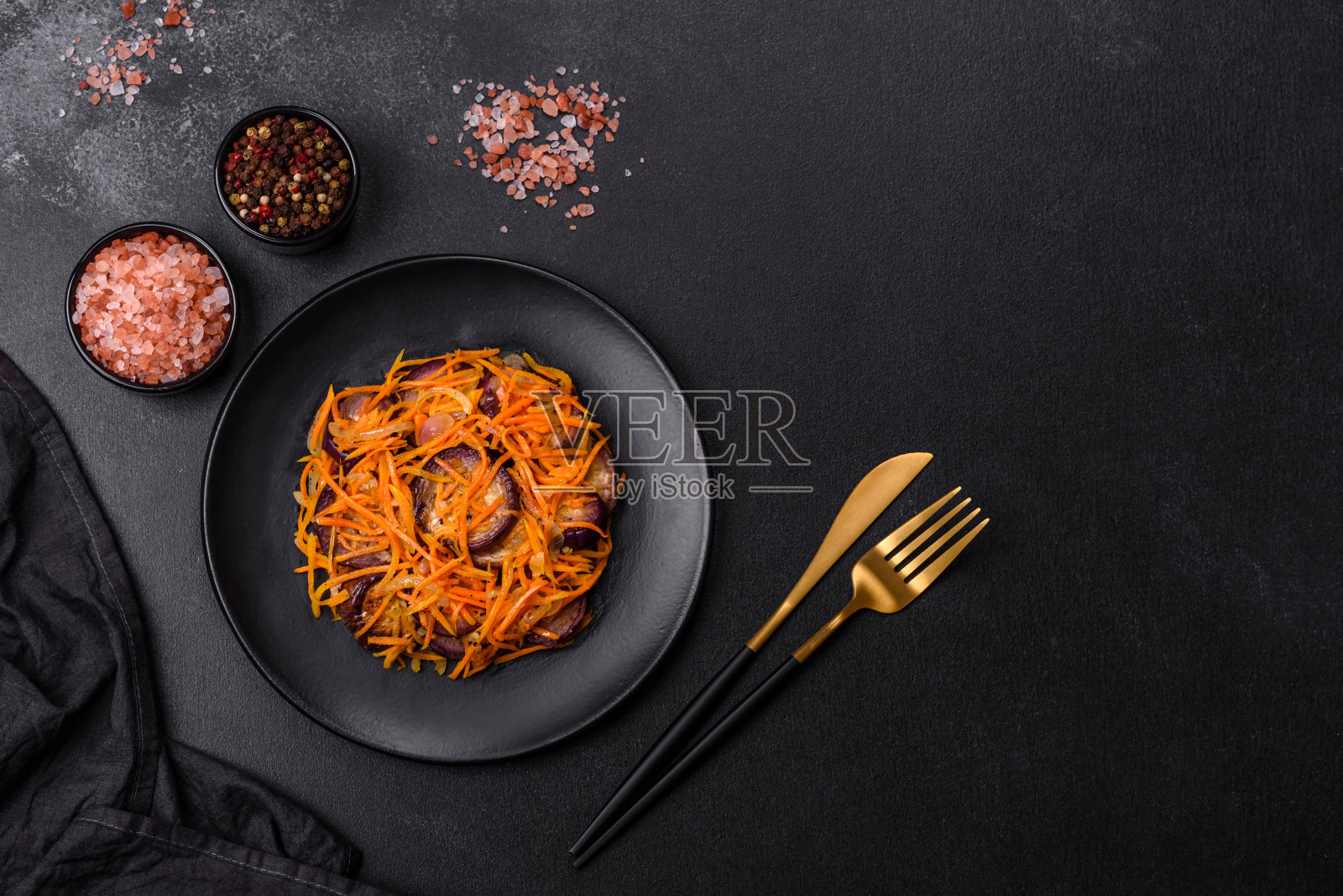 用茄子、胡萝卜、大蒜、香料和香草做的韩国沙拉，背景是深色的混凝土照片摄影图片